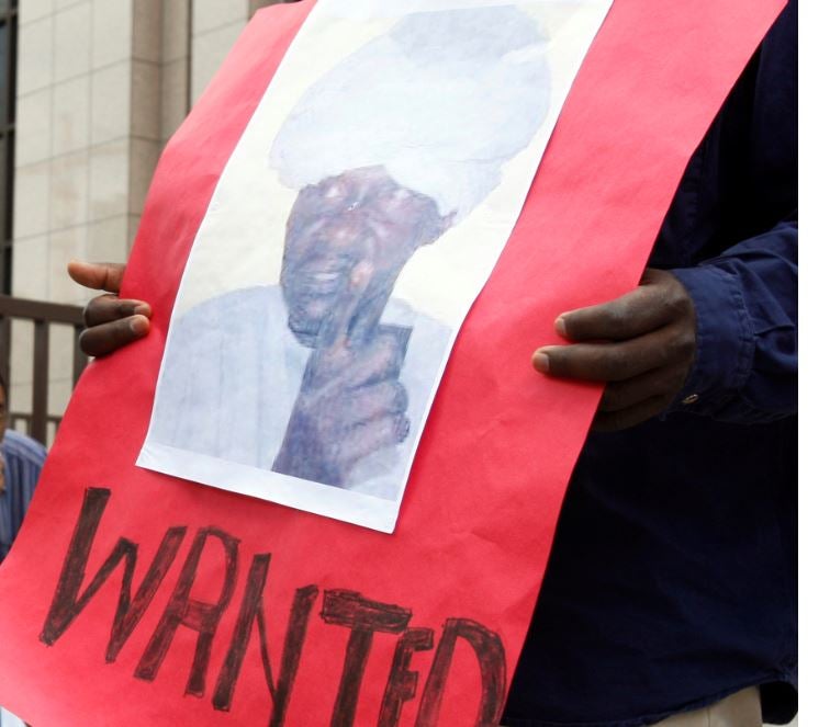  متظاهر يحمل لافتة عليها صورة علي كوشيب، أحد قادة ميليشيا "الجنجويد" السودانية، مع عبارة "مطلوب" بالإنغليزية، وآخر يحمل لافتة عليها صورة الرئيس آنذاك عمر البشير، مع عبارة "العدالة لدارفور" بالإنغليزية، أمام مقر "مجلس الاتحاد الأوروبي" في بروكسيل في يوليو/تموز 2008. الاثنان تتهمهما "المحكمة الجنائية الدولية" بارتكاب جرائم حرب. 