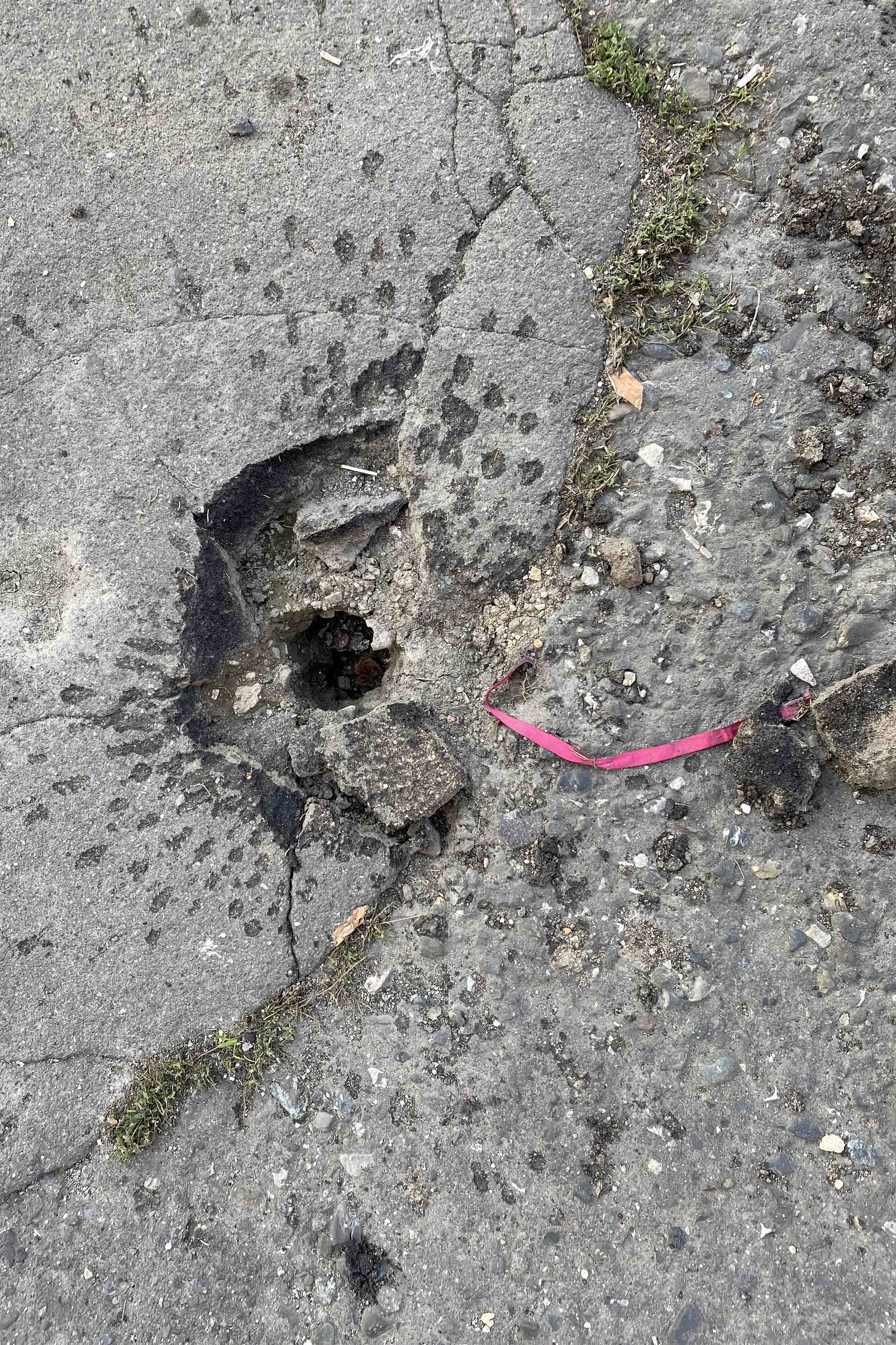 Ստեփանակերտում, Ղարաբաղ Տելեկոմի գլխավոր մասնաշենքի մոտակայքում, M095 երկակի նշանակության հրթիռի հարվածի բնորոշիչ հետքի օրինակը գետնին՝ իր վարդագույն գույնի ժապավենի հետ միասին: 