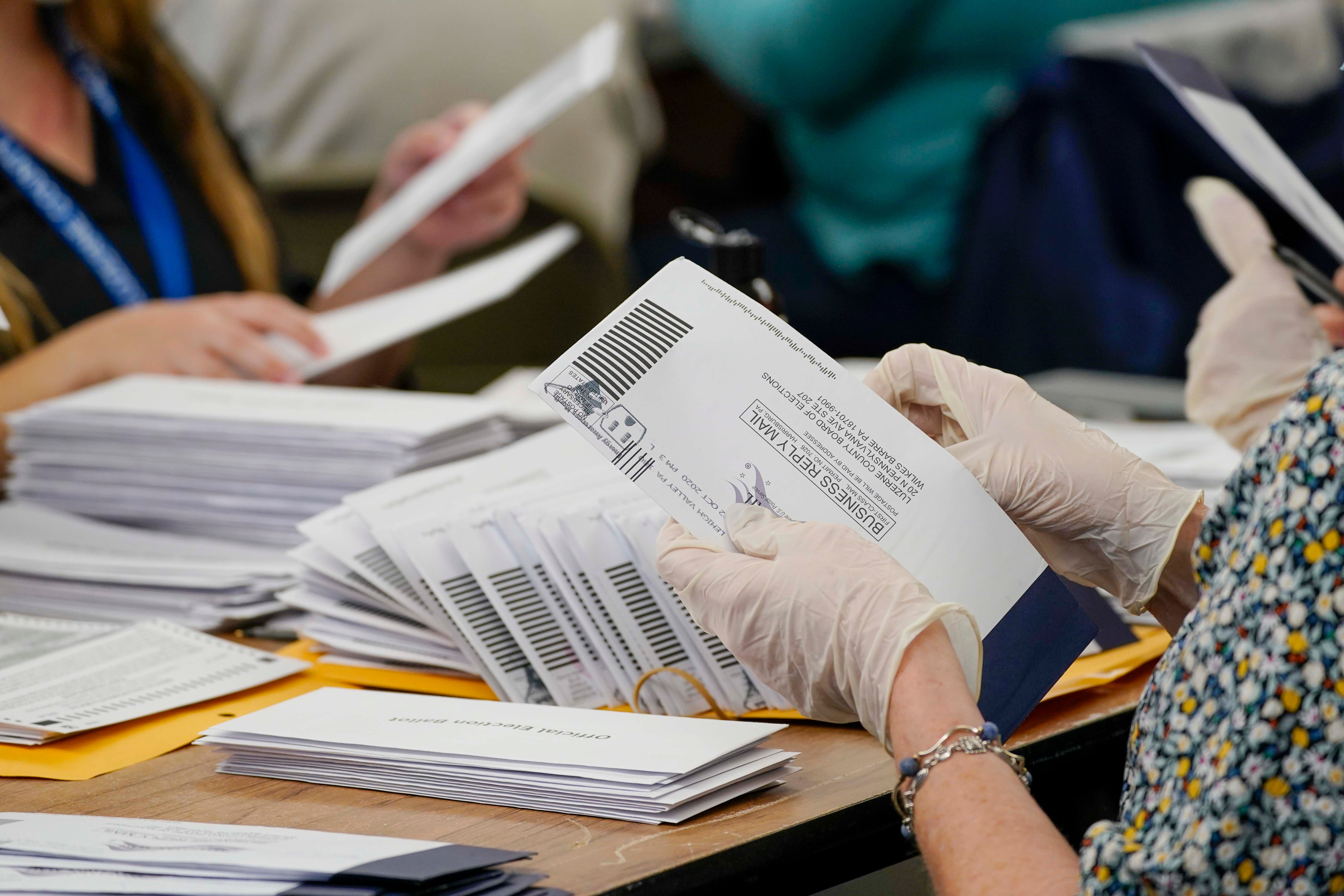 Municipal workers extract Luzerne County ballots from their envelopes, Wednesday, November 4, 2020, in Wilkes-Barre, Pennsylvania. 