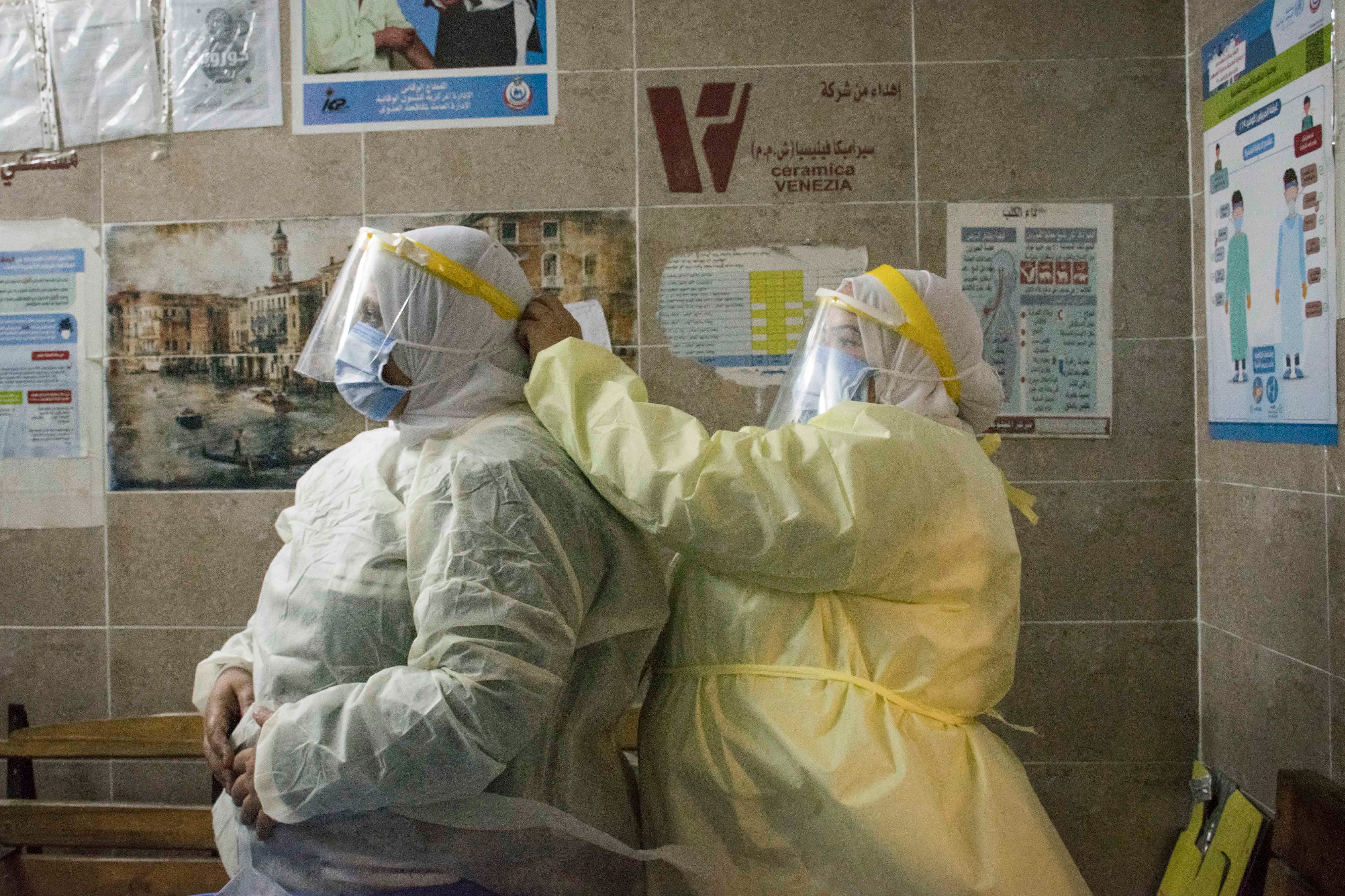 A nurse helps a colleague put on personal protective equipment at the 6th of October Central Hospital, an isolation hospital for Covid-19 patients, in Giza, Egypt, in July 2020.