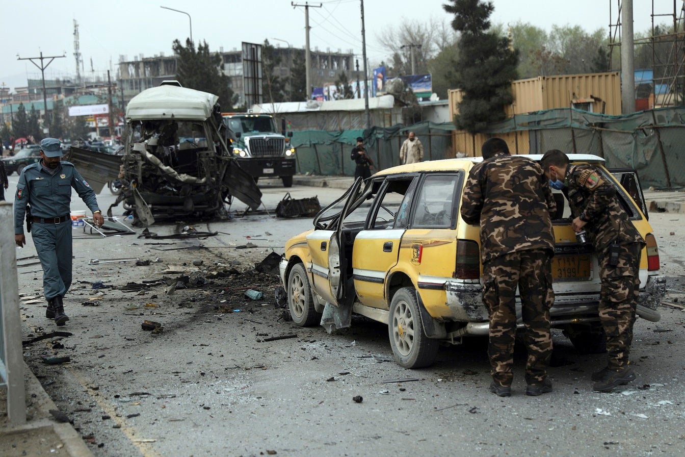 Security personnel inspect the site of a bomb attack in Kabul, Afghanistan on Monday, March 15, 2021. 