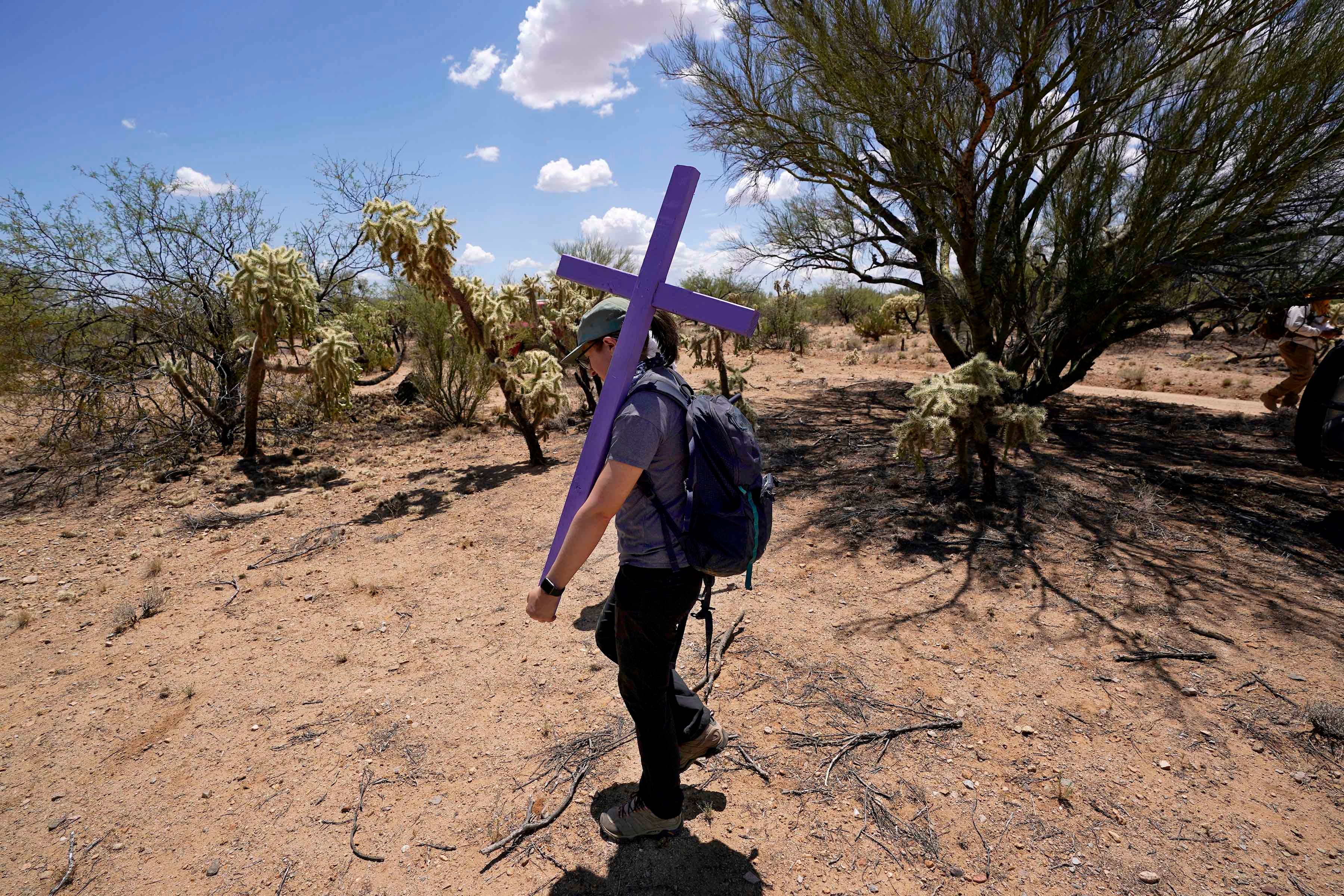 Alyssa Quintanilla, part of the Tucson Samaritans volunteer group, carries a cross, May 18, 2021, to be installed near Three Points, Arizona. The cross will be installed in the desert to commemorate the death of a migrant there. 