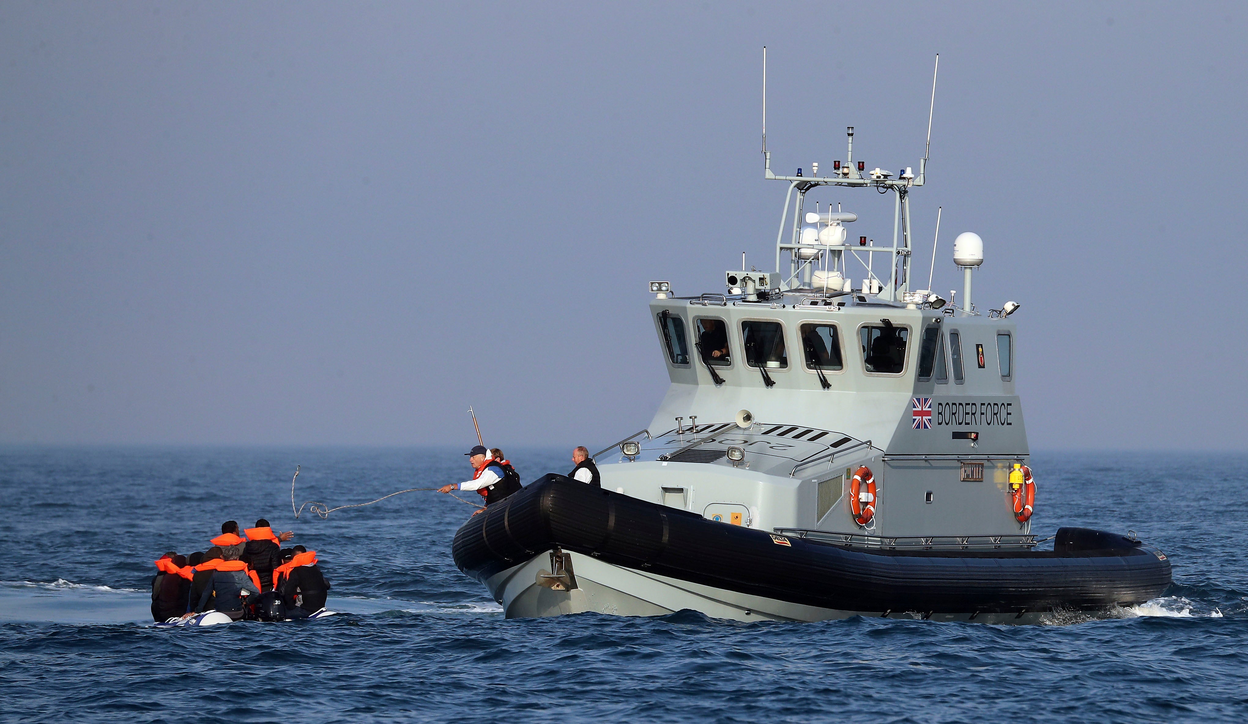 Border Force officers assist 20 Syrian migrants aboard HMC Hunter after they were stopped as they crossed The Channel in an inflatable dinghy headed in the direction of England.