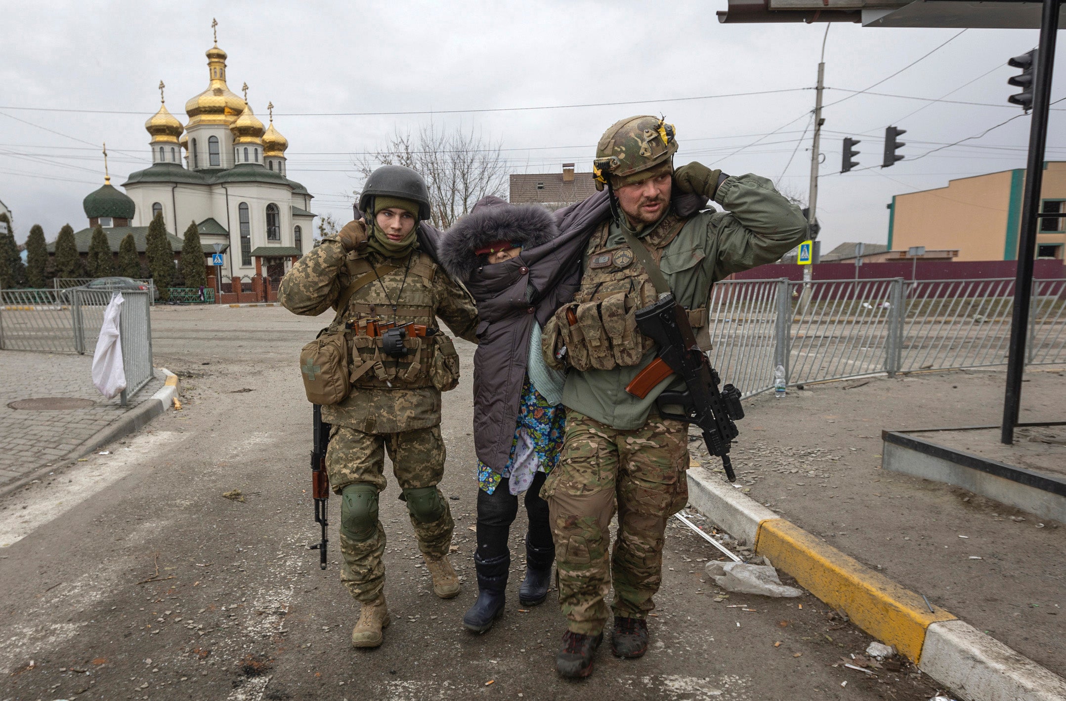 Ukrainian soldiers help a woman in the town of Irpin, Ukraine on March 6.