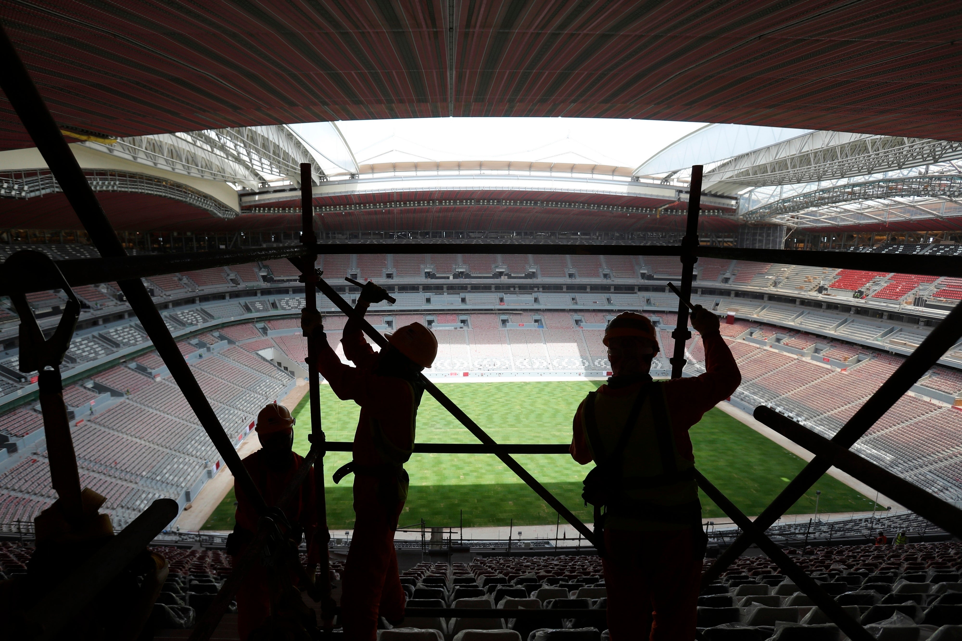 Laborers remove scaffolding at the Al Bayt stadium in Al Khor, Qatar, Monday, April 29, 2019.