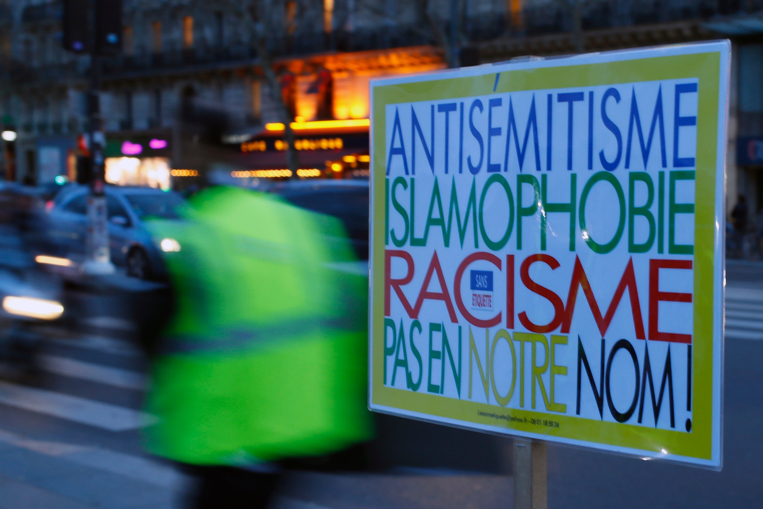 A poster reading "Anti-Semitism, Islamophobia, Racism, Not in Our Name" during a gathering decrying anti-semitism at Place de la Republique in Paris, February 18, 2019.