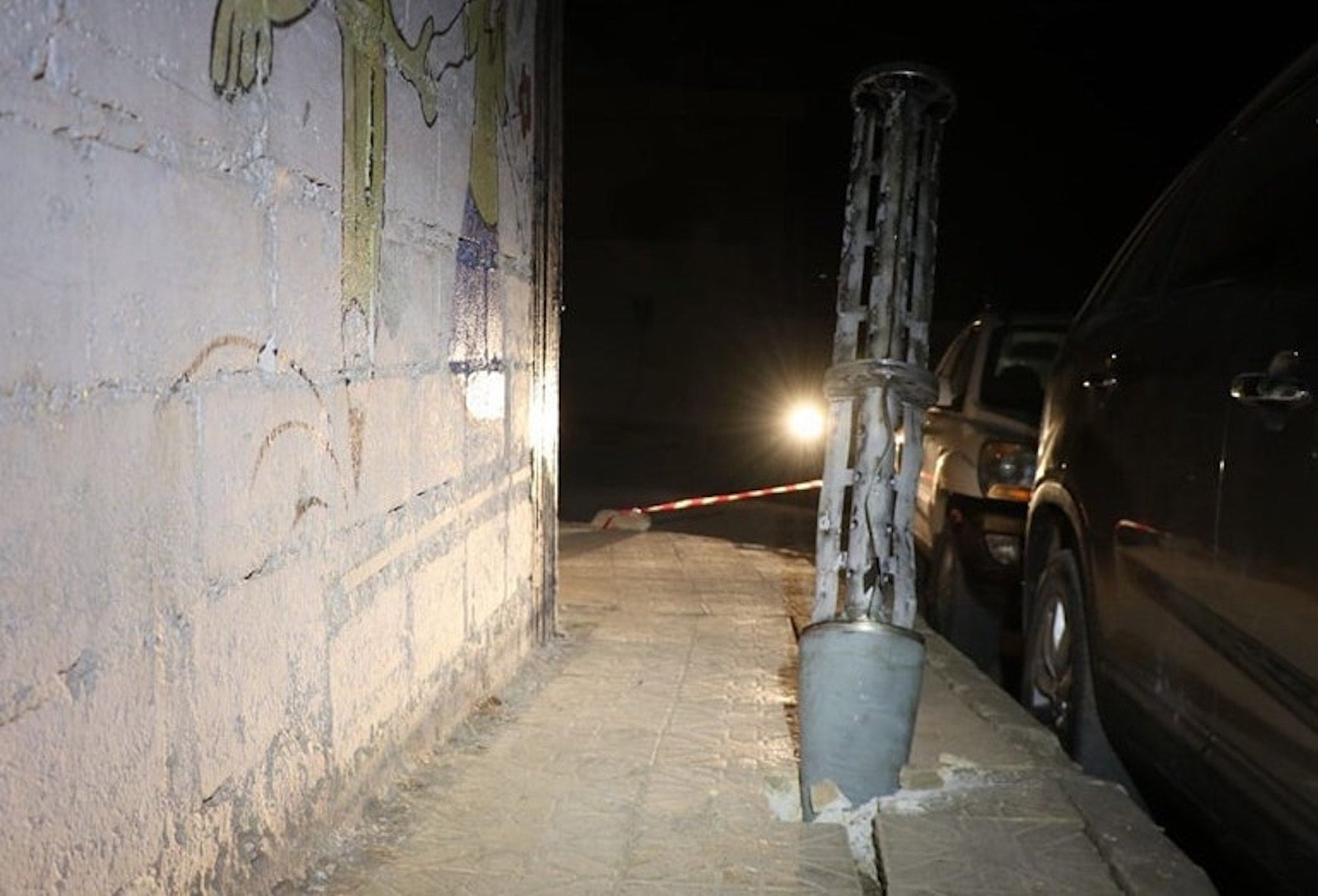 Remnant of an expended cargo section of one of the two 220mm 9M27K-series Uragan surface-launched cluster munition rockets embedded into the ground after it scattered its payload of explosive submunitions on a sidewalk next to a boys’ school in the town of Termanin, Syria 2023.