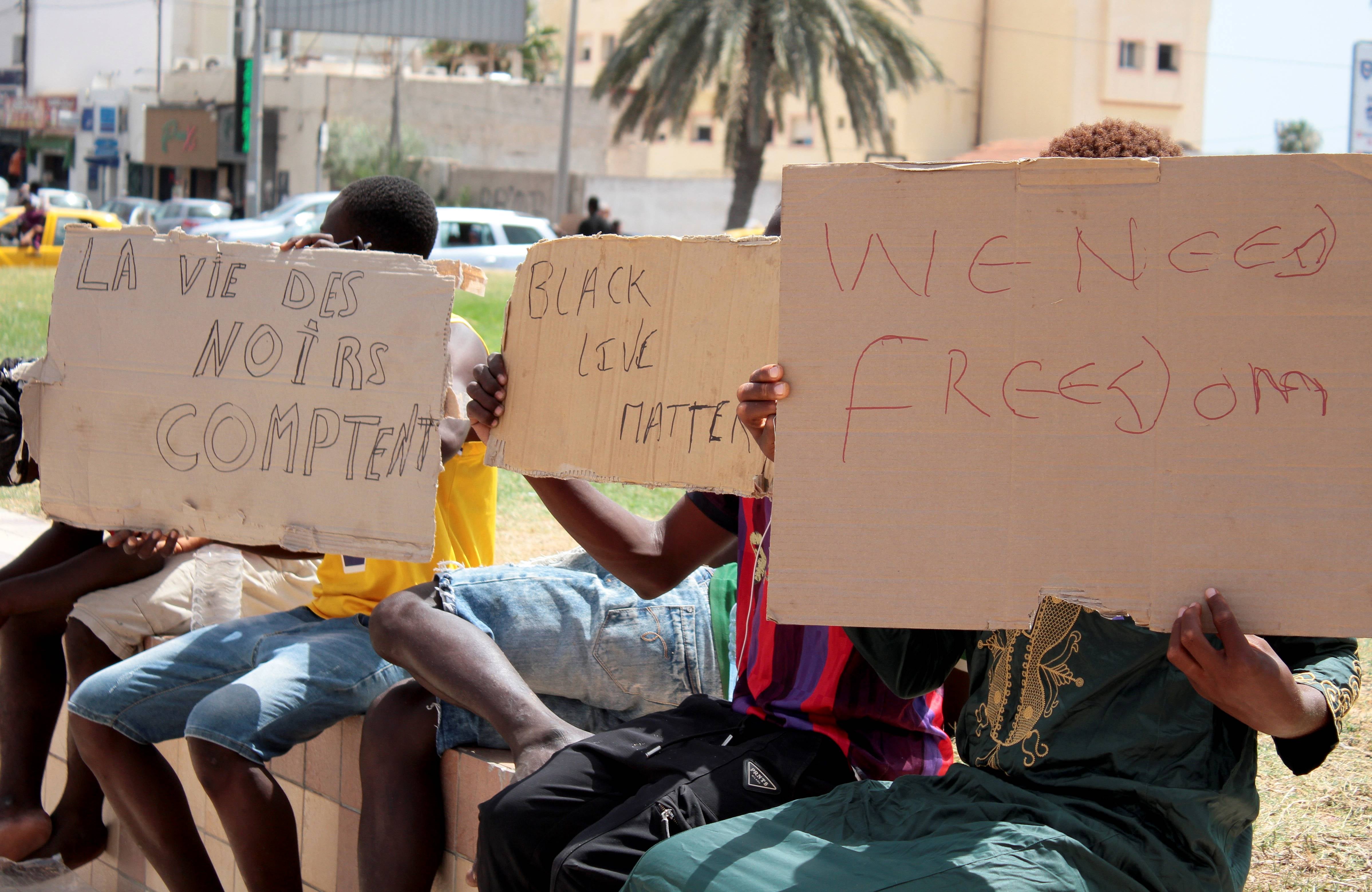 Migrants hold placards reading "Black Lives Matter", left in French, during a gathering in Sfax, Tunisia's eastern coast, on July 7, 2023.