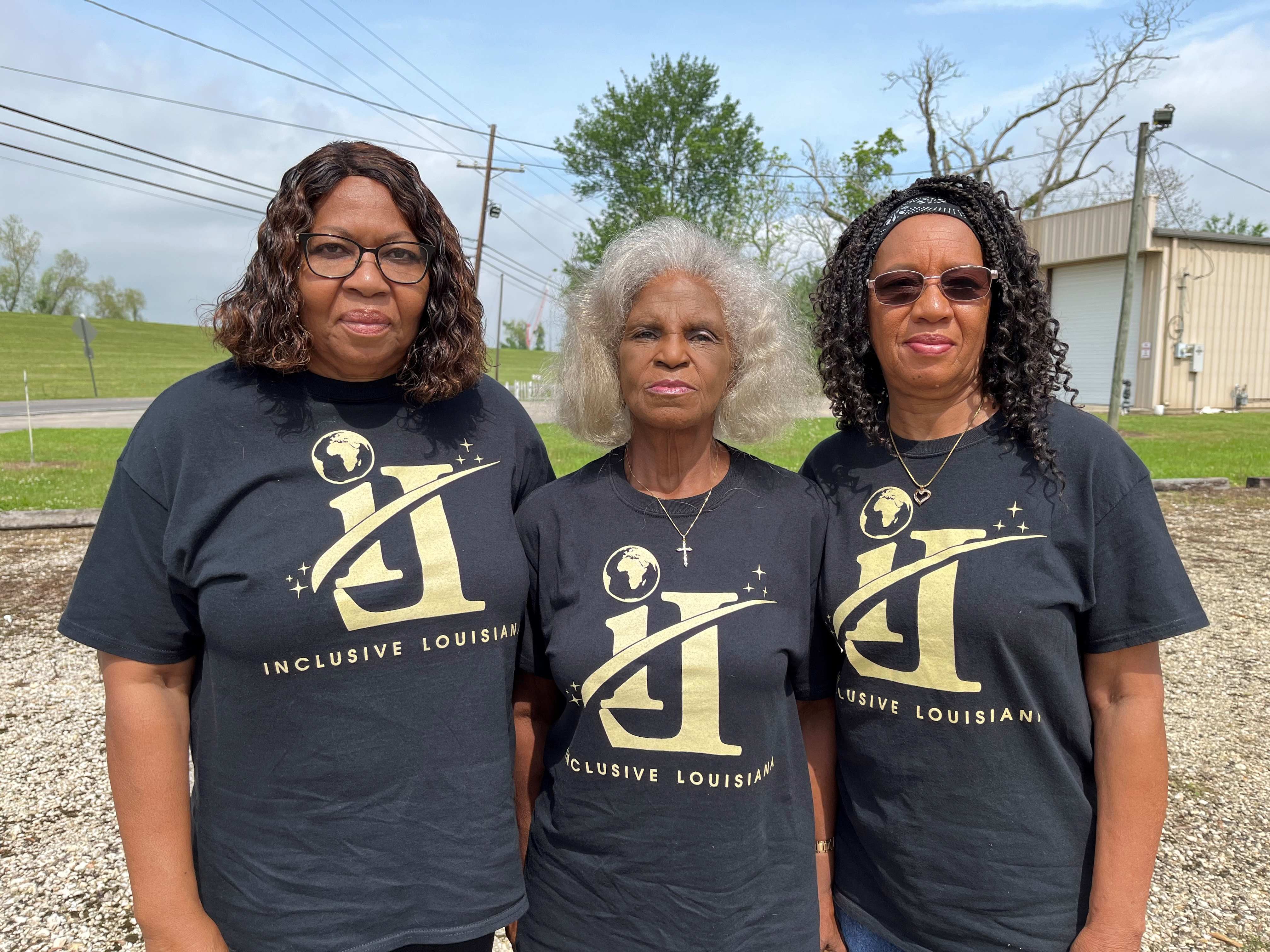 3 women wearing matching shirts pose for a photo