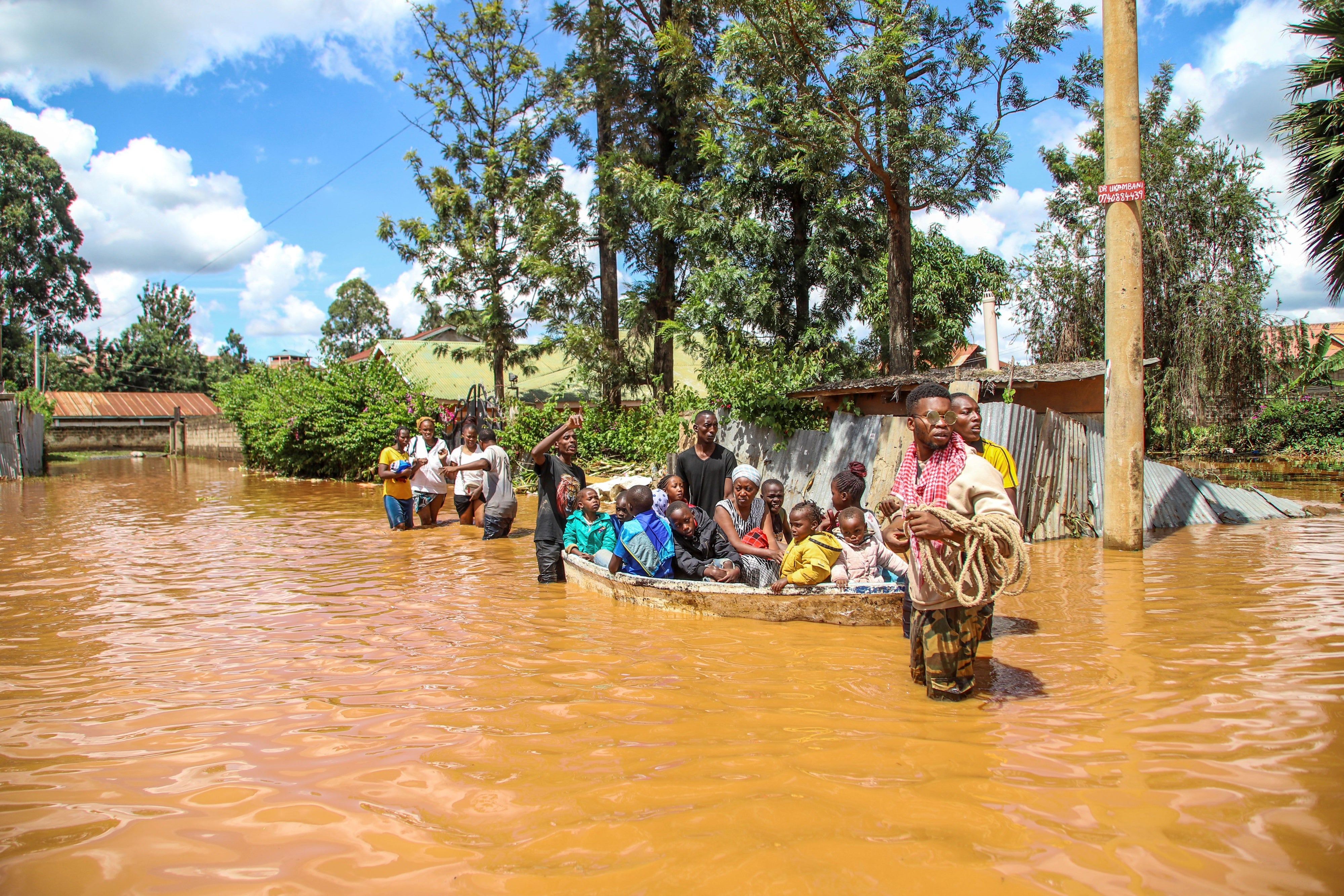 A family uses a boat after fleeing floodwaters that wreaked havoc in the Githurai area of Nairobi, Kenya, April 24, 2024.