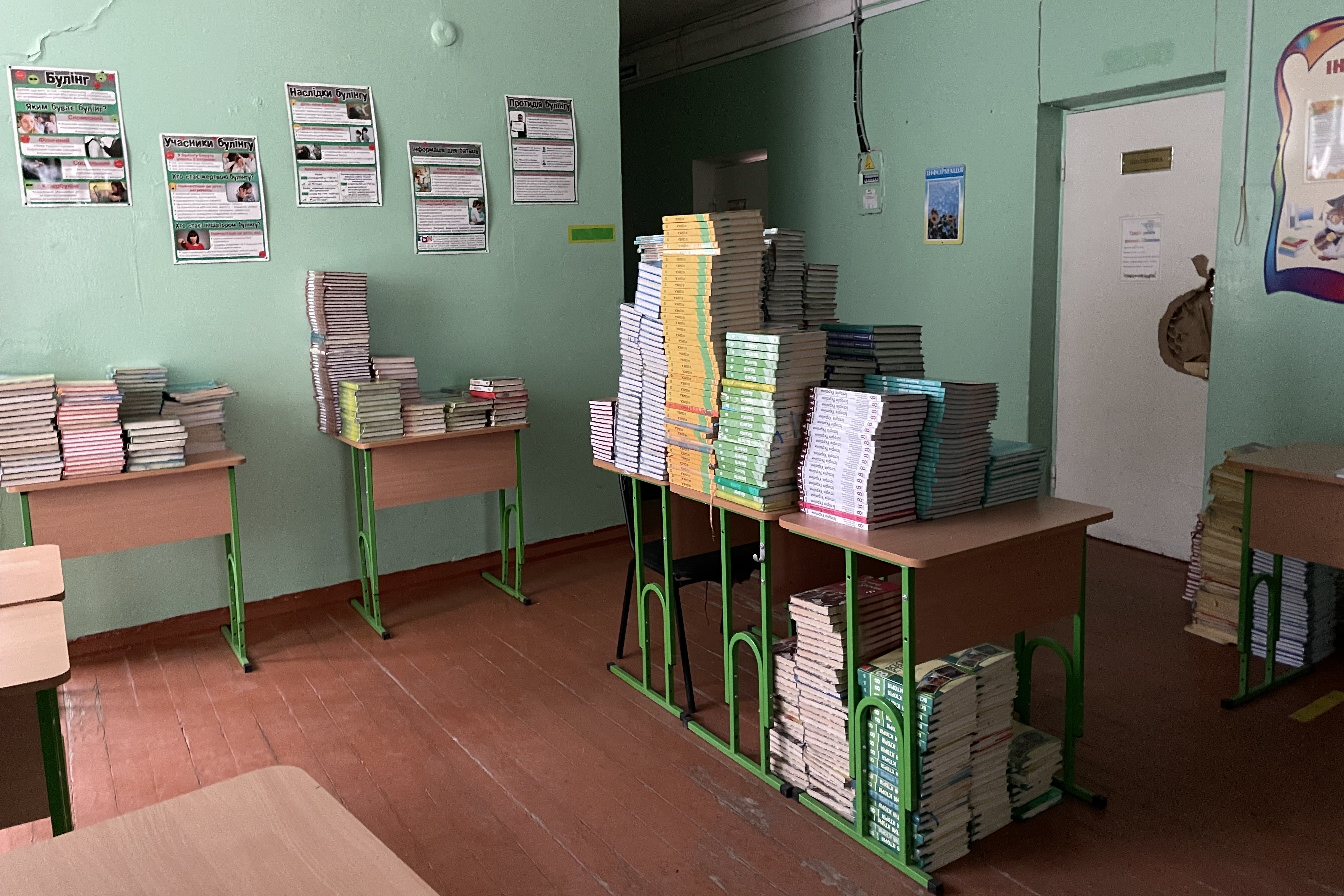 Stacks of textbooks on desks in a classroom