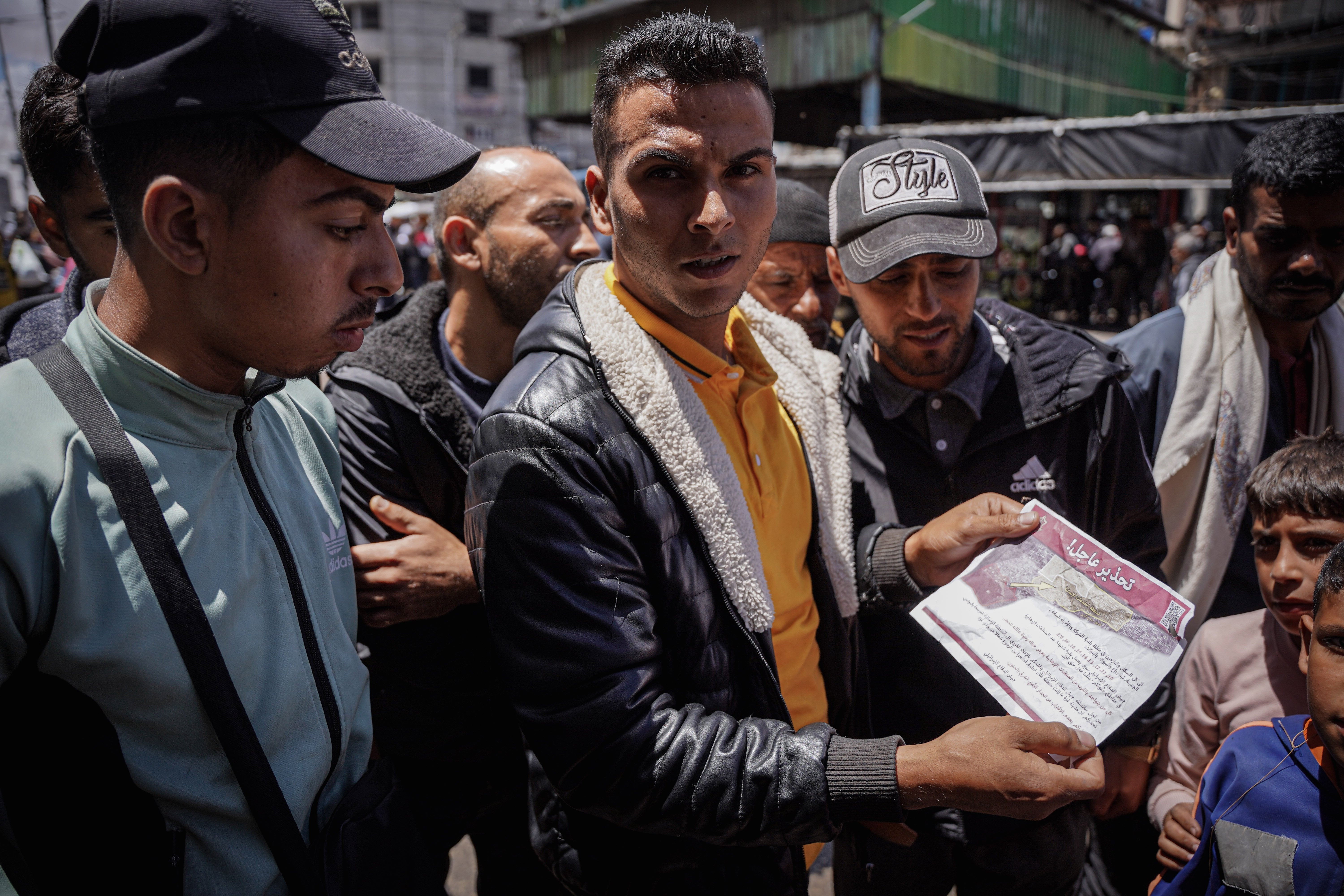 A group of Palestinians read a warning leaflet dropped by Israeli warplanes