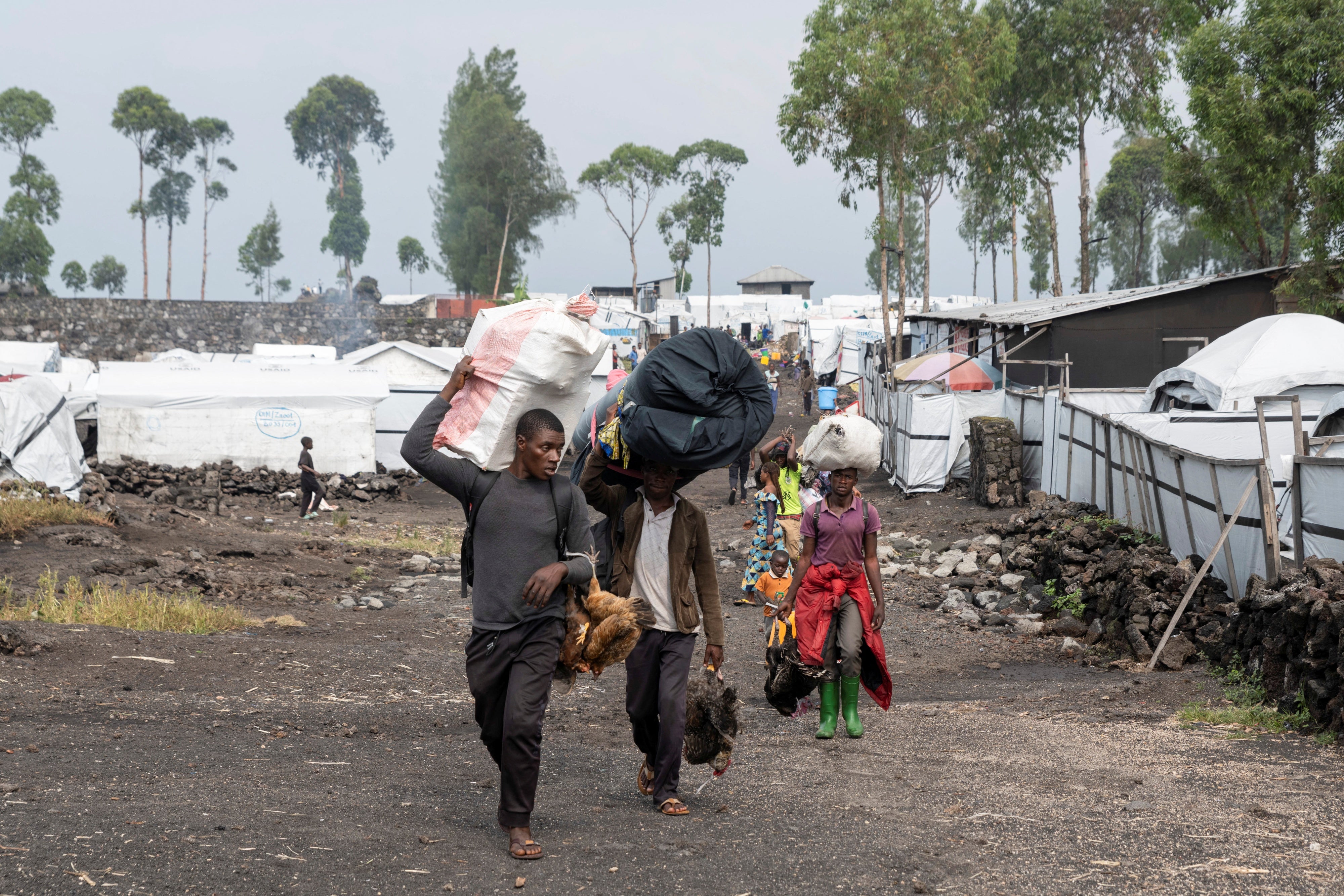 Des civils fuient le camp de déplacés de Nzulo vers Goma.
