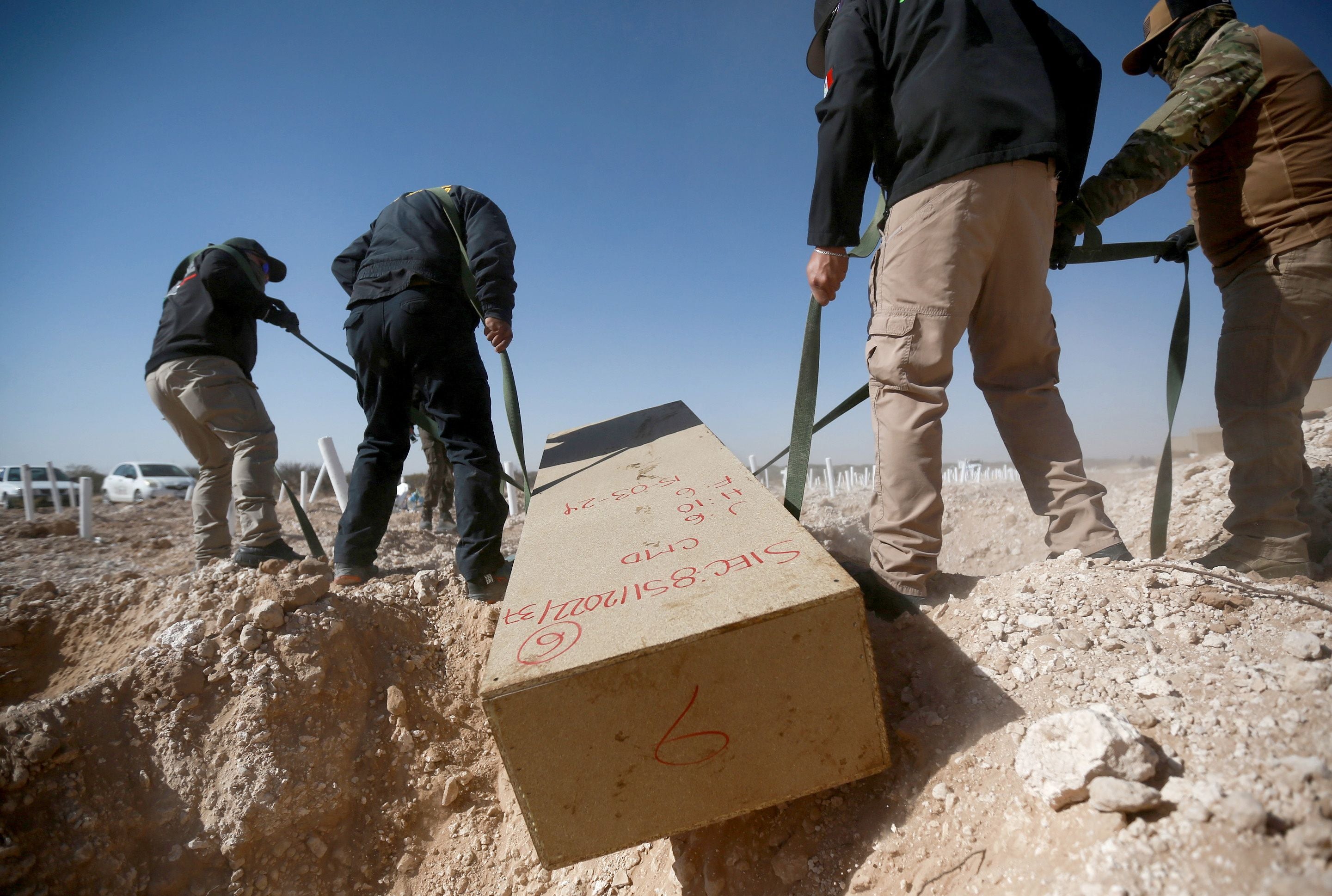 Des employés d’un département municipal médico-légal plaçaient un cercueil improvisé contenant le corps d’une victime de homicide non identifiée dans une fosse commune près de Ciudad Juárez, dans l’État de Chihuahua au Mexique, le 15 mars 2024.