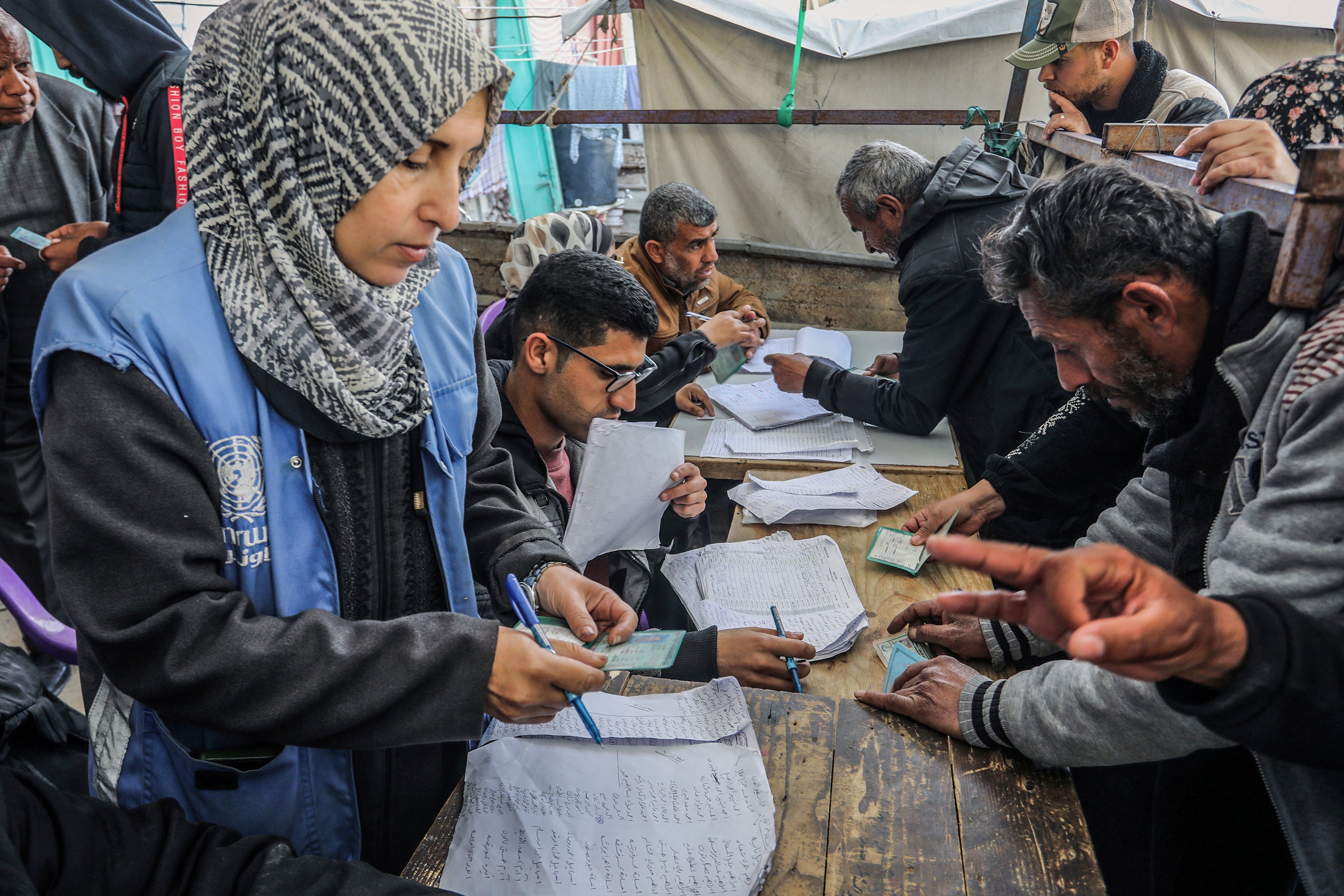 Palestinians receive humanitarian aid from the United Nations Relief 