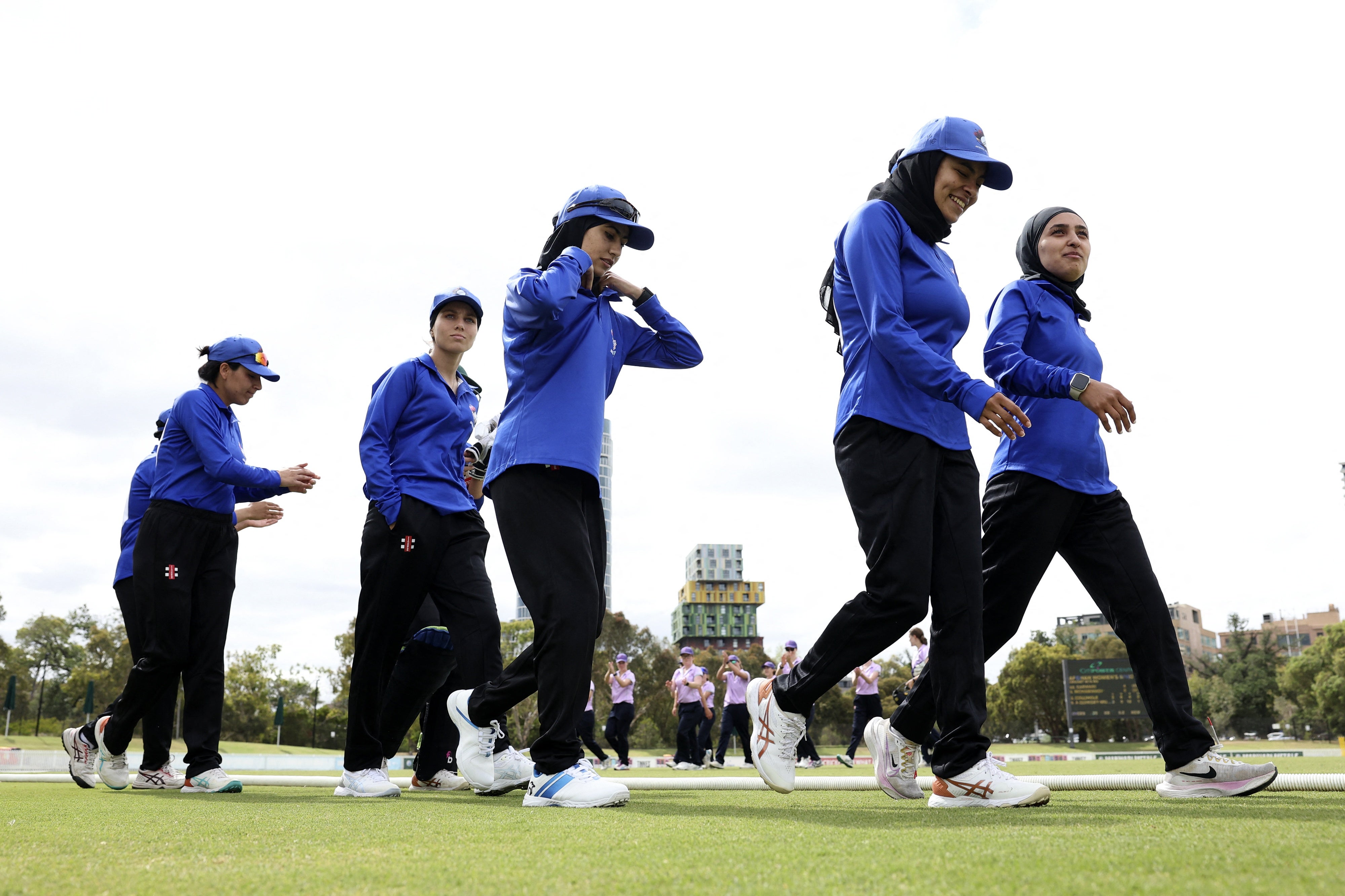 Afghan women cricket players prepare to take the field during the match between Afghanistan Women's XI and Cricket Without Borders XI in Melbourne, Australia, January 30, 2025.