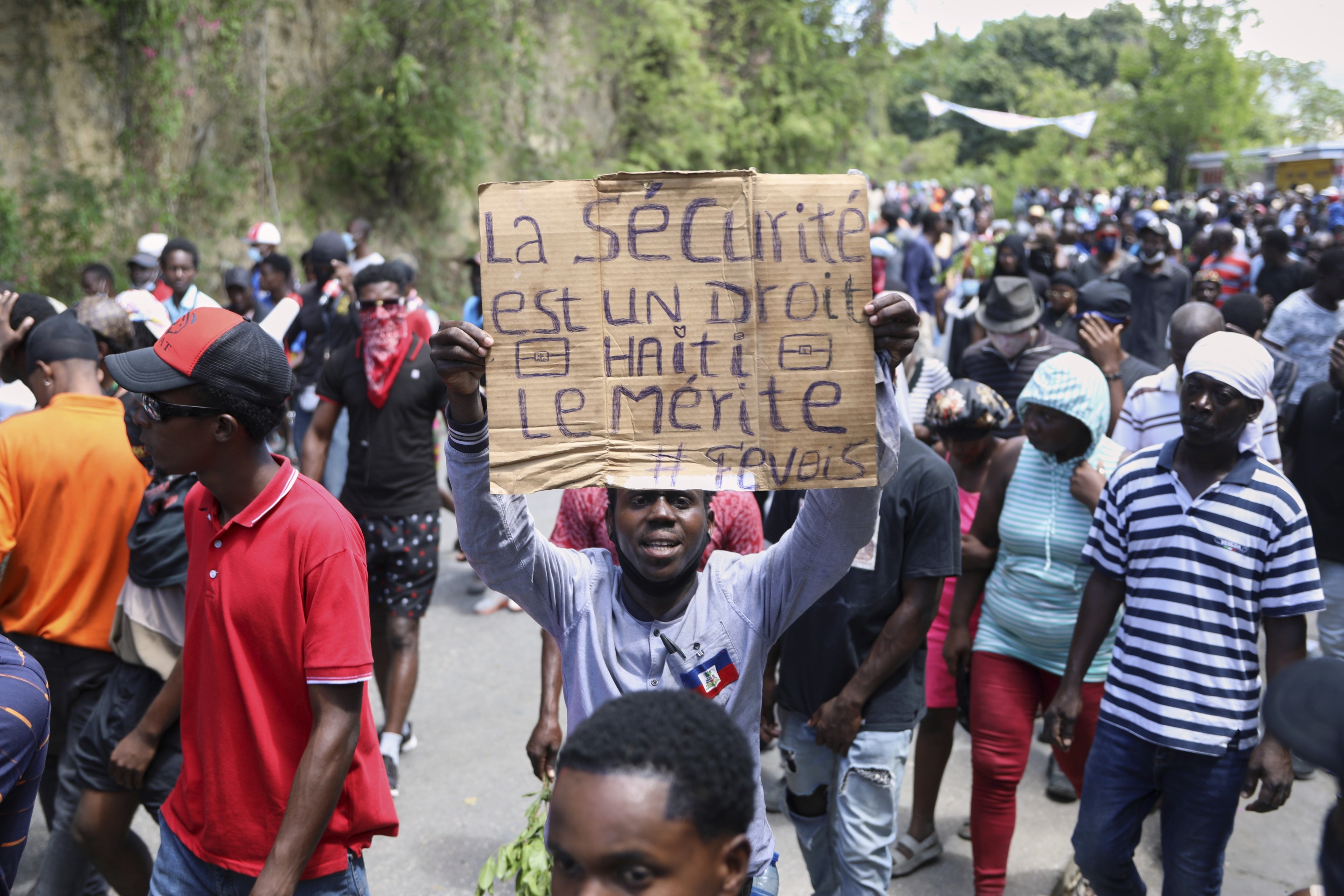 A protester holds up a sign that reads in French, "Security is a right, Haiti deserves it" during a demonstration in Port-au-Prince, Haiti, April 2, 2025.