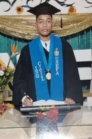 A young man wearing graduation robes