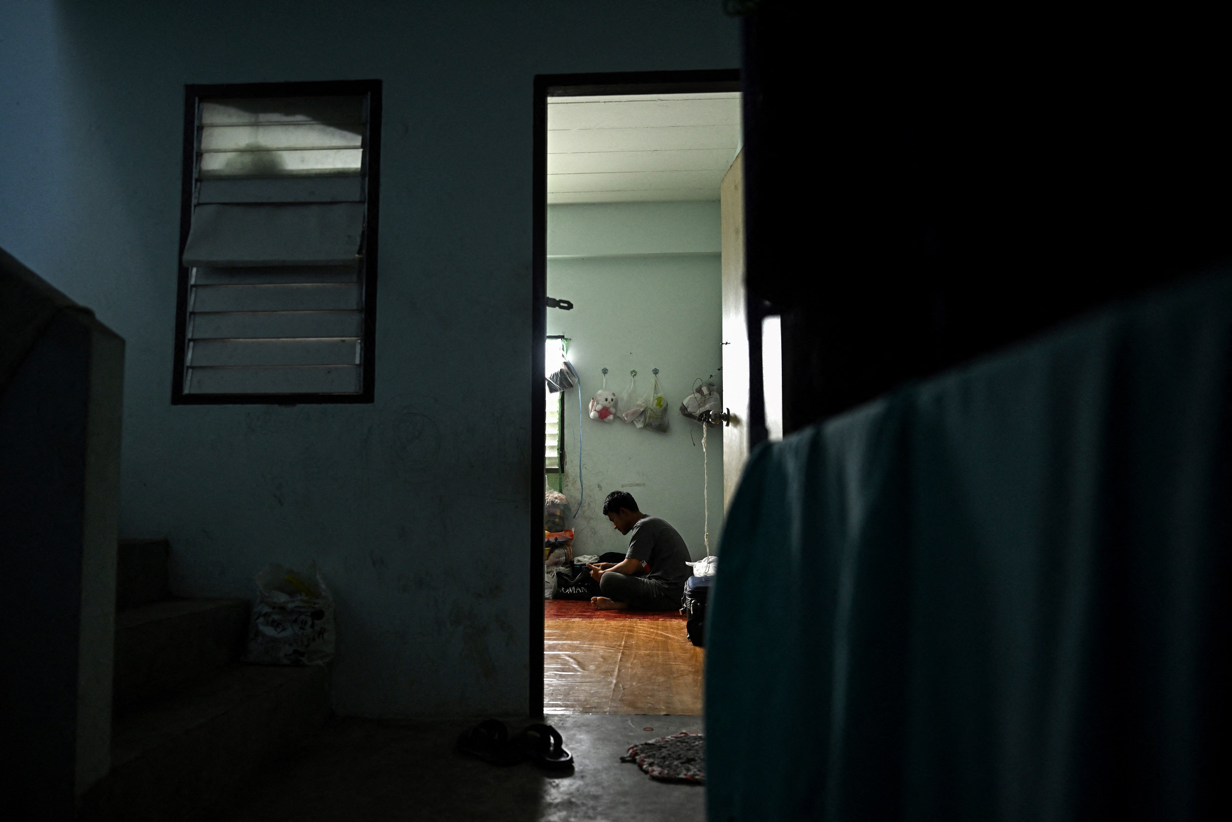 A man sits inside his apartment.