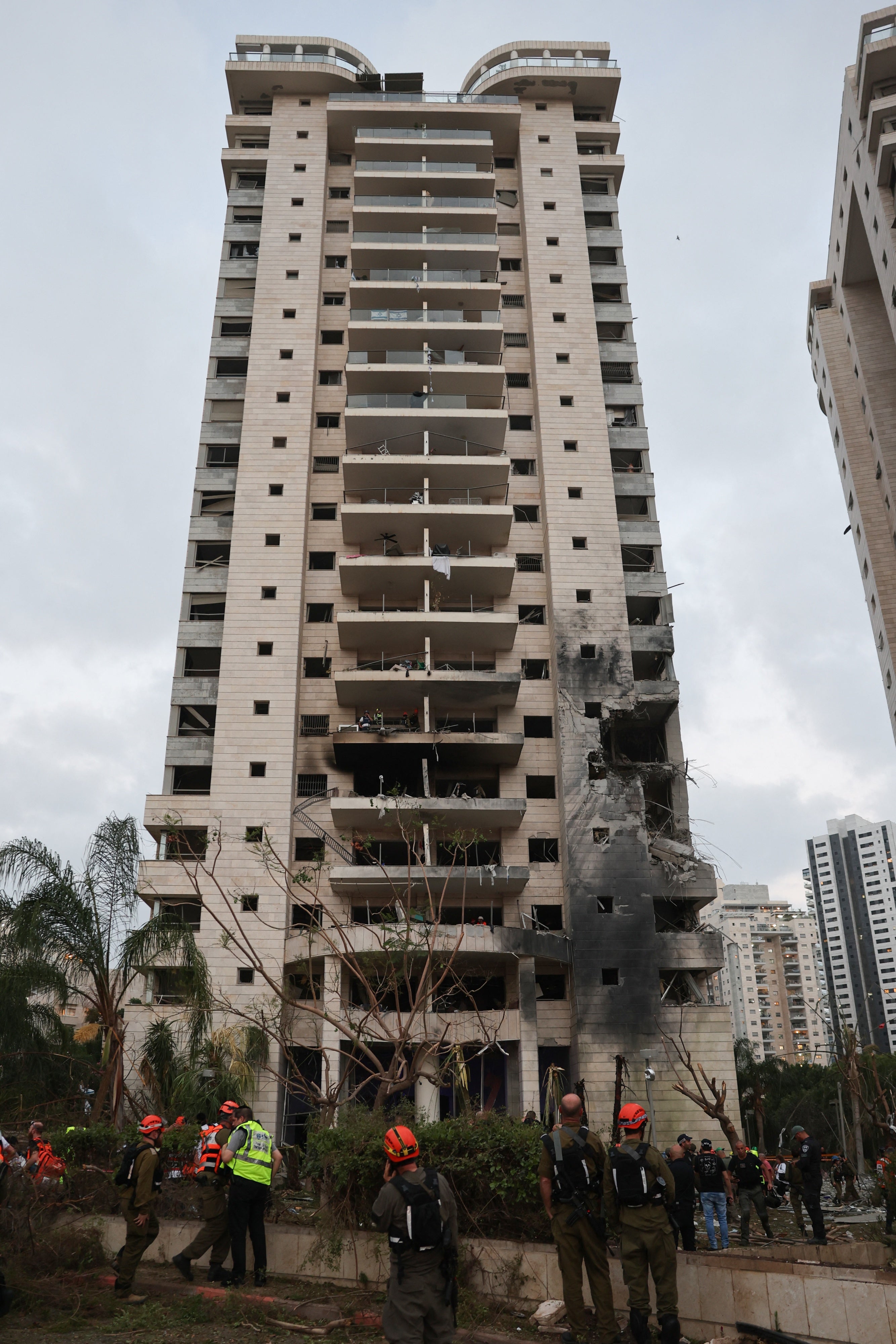 Responders next to the building struck by an Iranian ballistic missile on the Israeli city of Petah Tikva, east of Tel Aviv, on June 16, 2025.