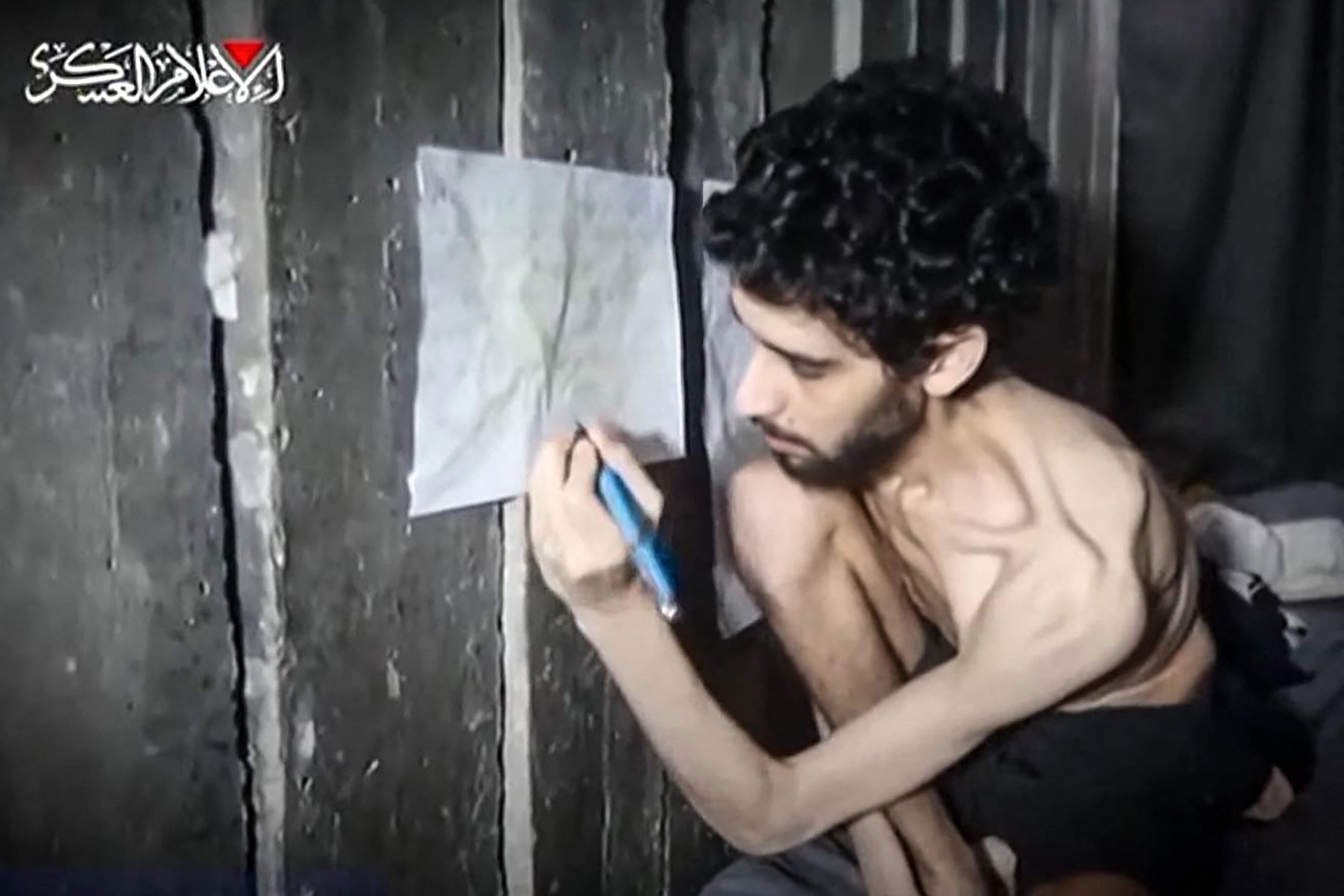 Screen grab of August 1, 2025 video published by Hamas’ armed wing showing emaciated 24-year-old Israeli hostage Evyatar David in a tunnel sitting next to a chart that he says tracks his extremely limited food intake.