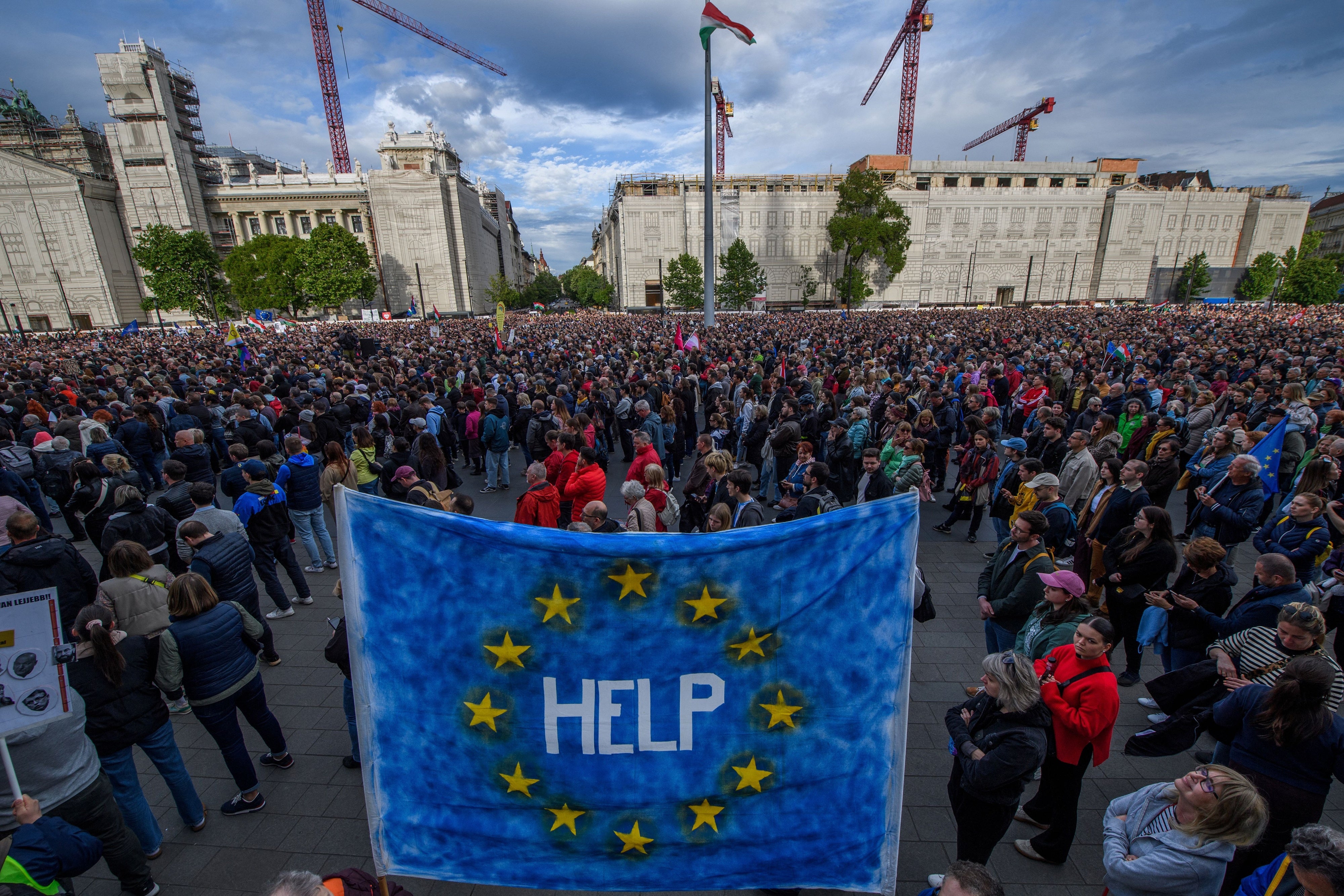 A protester holds up an EU flag with "help" written on it, during a demonstration in Budapest on May 18, 2025 against a bill empowering the government to sanction civil society organizations and media it deems threats to the country's sovereignty.