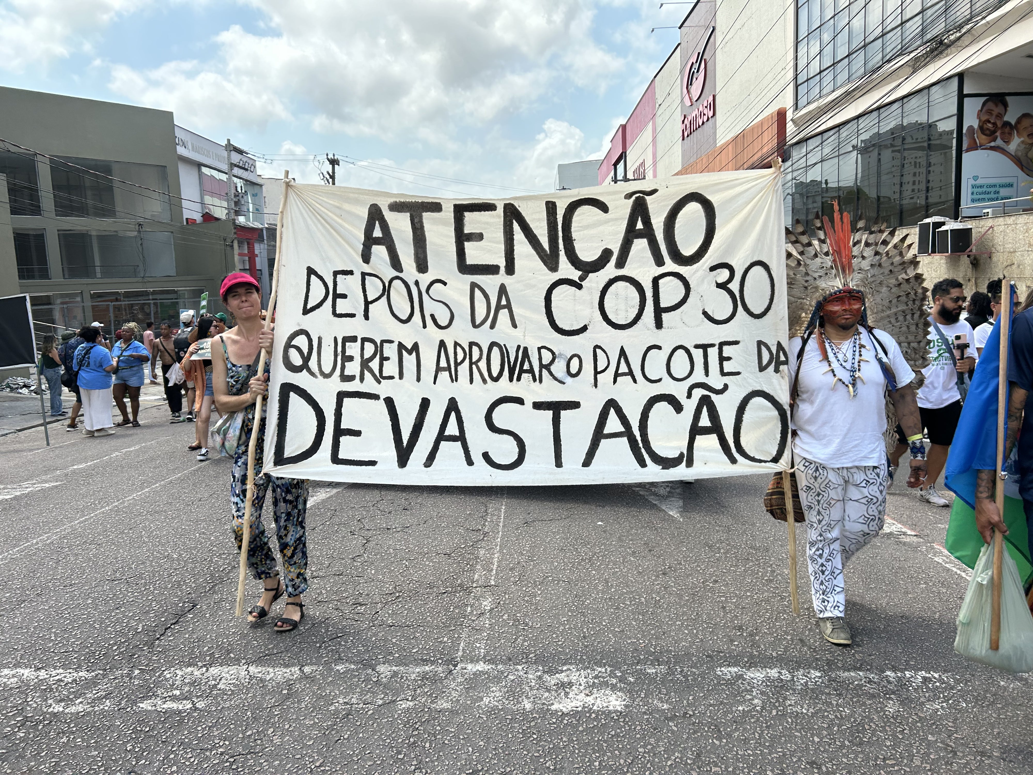 Activists carry a banner warning of efforts to dismantle environmental licensing requirements in Brazil.