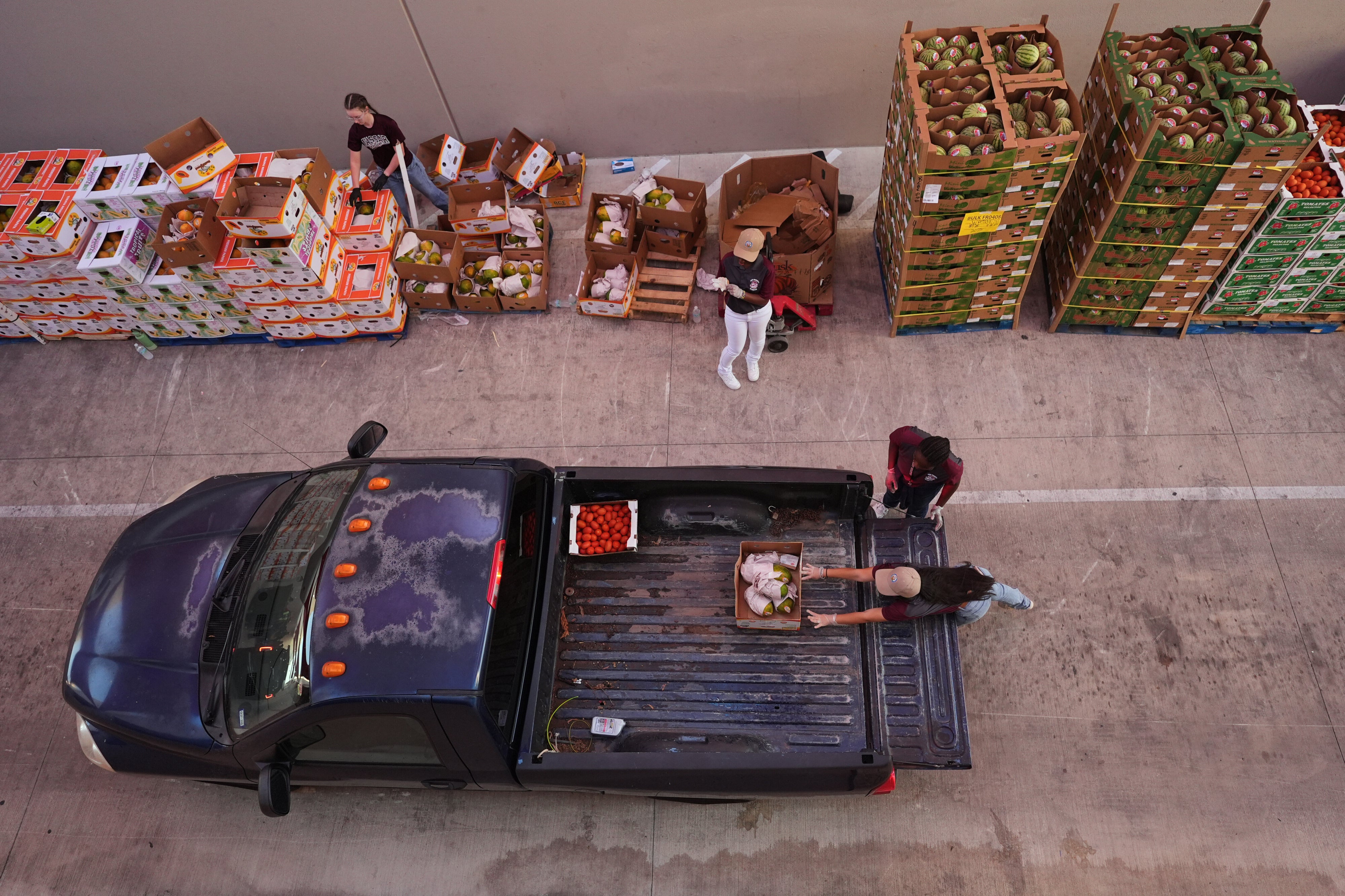 Volunteers help load vehicles during a food distribution at the San Antonio Food Bank for SNAP recipients and other households affected by the US federal shutdown, November 6, 2025. 