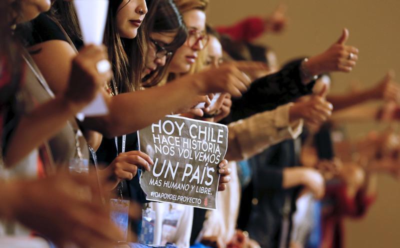 Demonstrators raie their thumbs in approval during a rally inside congress in favor of a draft law by the government, which seeks to ease the country's strict abortion ban, in Valparaiso, Chile March 17, 2016. The banner reads: "Chile makes history today,