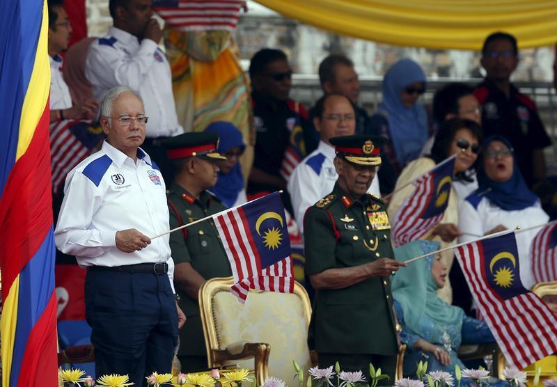 Malaysia's (L-R) Prime Minister Najib Razak and King Abdul Halim Mu'adzam Shah wave Malaysian national flags during National Day celebrations in Kuala Lumpur, August 31, 2015.