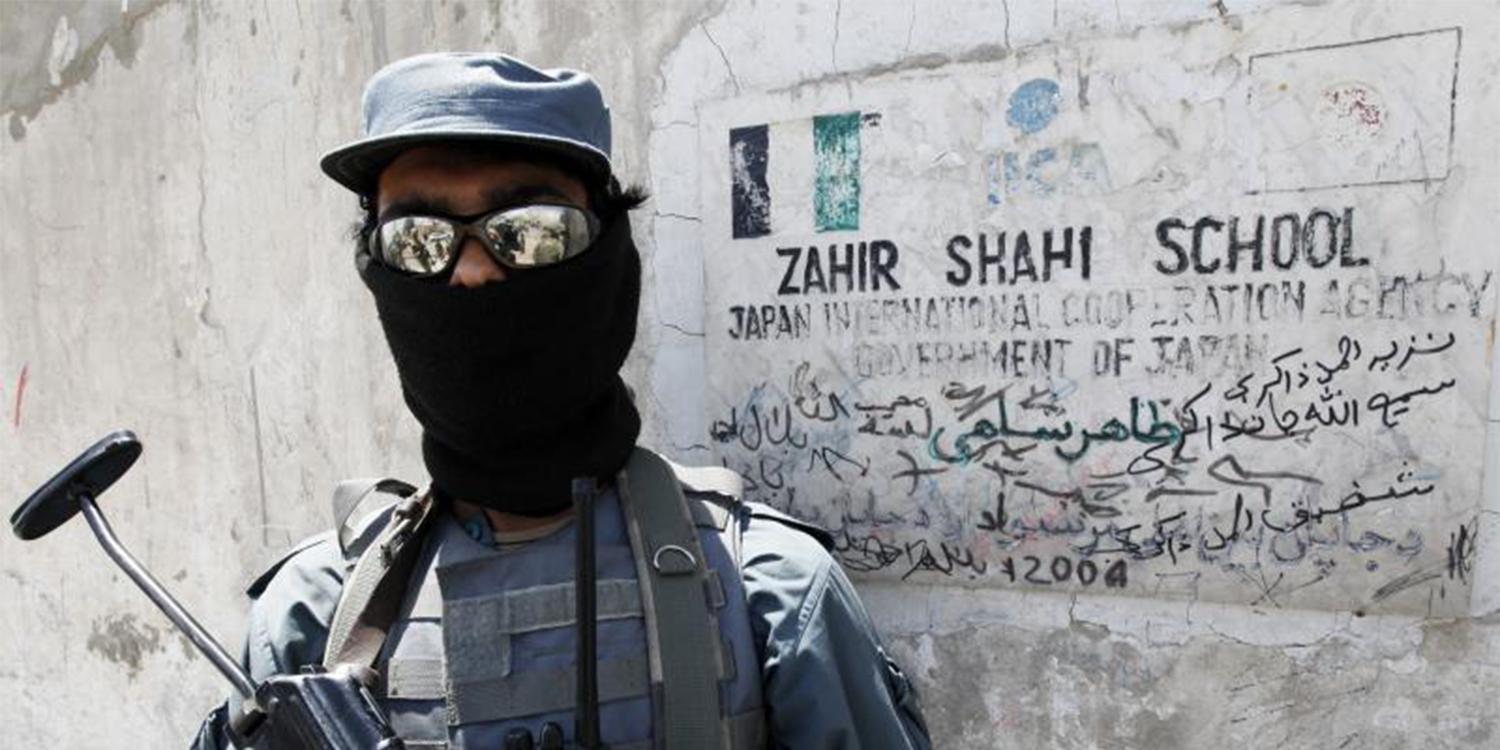 An Afghan policeman stands guard at the entrance of a local school sponsored by Japan’s International Cooperation Agency in Kandahar City May 11, 2010. © 2010 Nikola Solic / Reuters