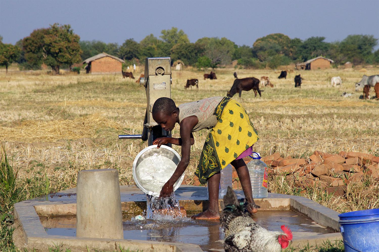 Young girl washing dishes at a borehole near Eland coal mine in Mwabulambo, Karonga district. 