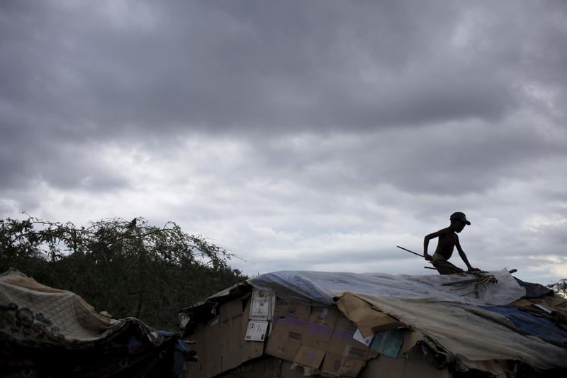 A boy fixes the roof of a makeshift tent at a refugee camp for Haitians returning from the Dominican Republic on the outskirts of Anse-a-Pitres, Haiti, September 6, 2015.
