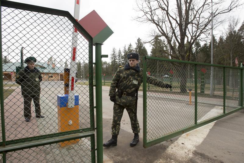 A Belarussian border guard closes the gate at a border crossing with Poland, near the village of Pererov, southwest of Minsk, March 31, 2015.