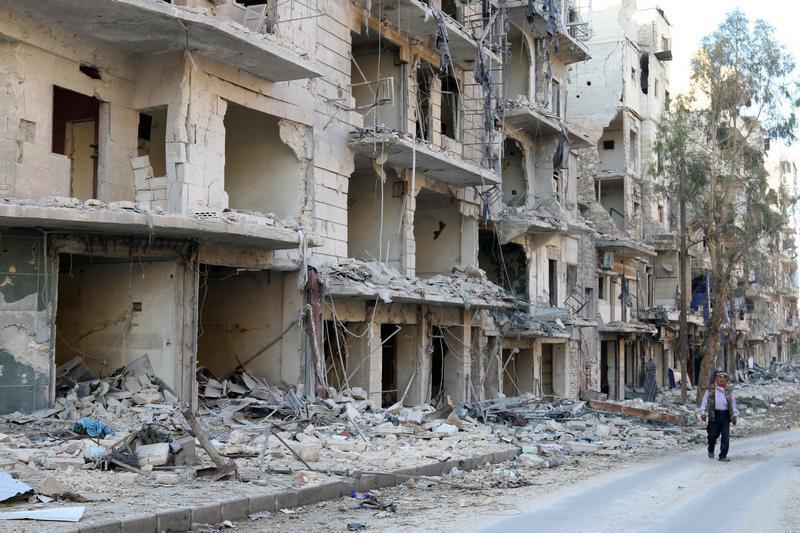 A man walks past damaged buildings in the rebel held besieged al-Sukkari neighbourhood of Aleppo, Syria October 19, 2016. 
