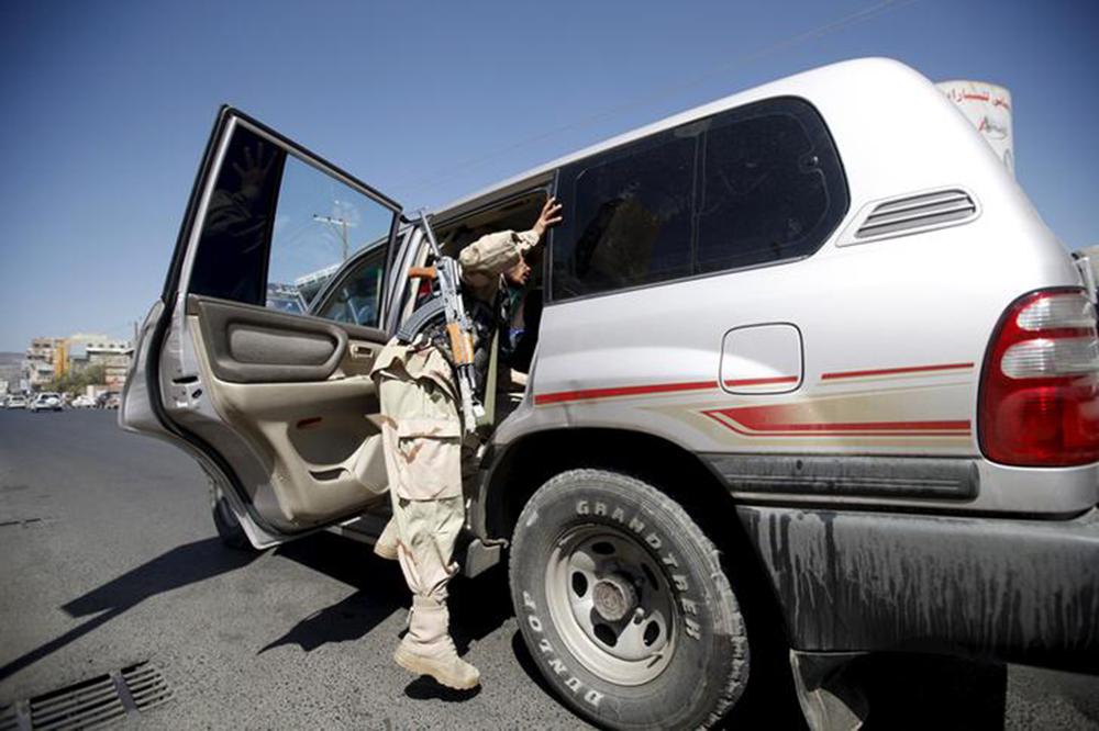 A Houthi fighter checks a van at a checkpoint on a street in Yemen's capital Sanaa October 21, 2015.