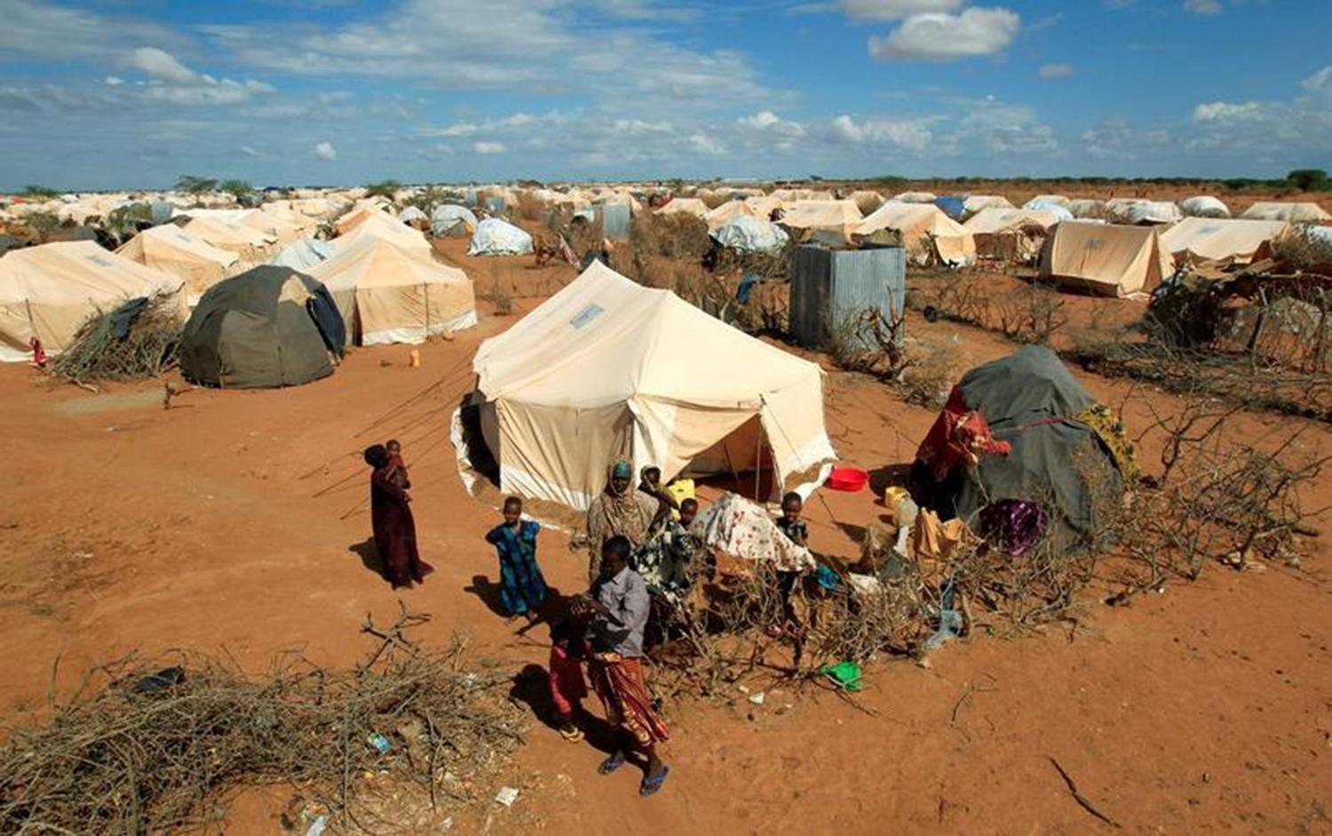 Photo: Refugees stand outside their tent at the Ifo Extension refugee camp in Dadaab, near the Kenya-Somalia border in Garissa County, Kenya, October 19, 2011. 