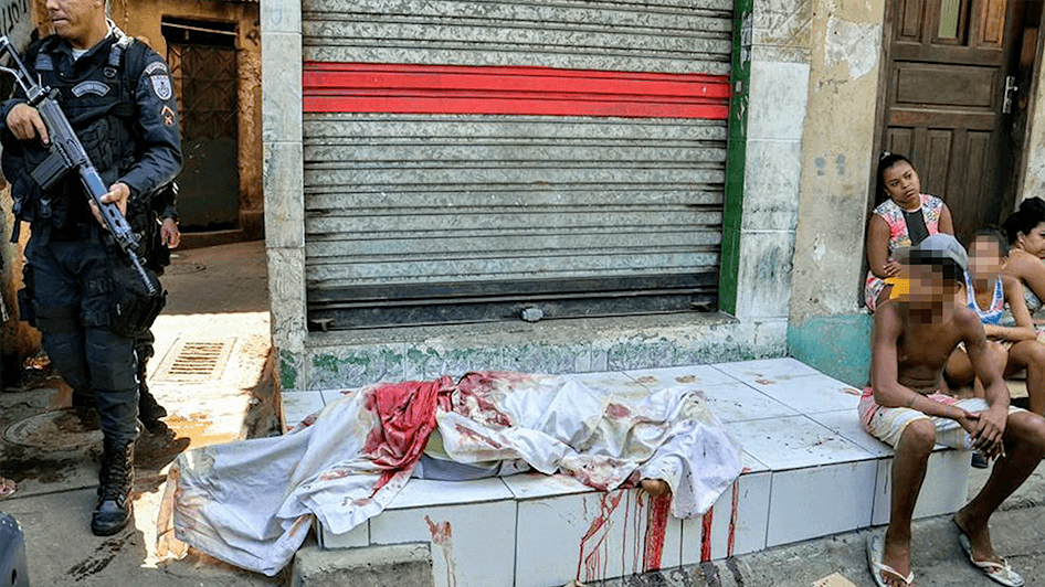 A picture showing a police man standing near a body covered with white cloth.