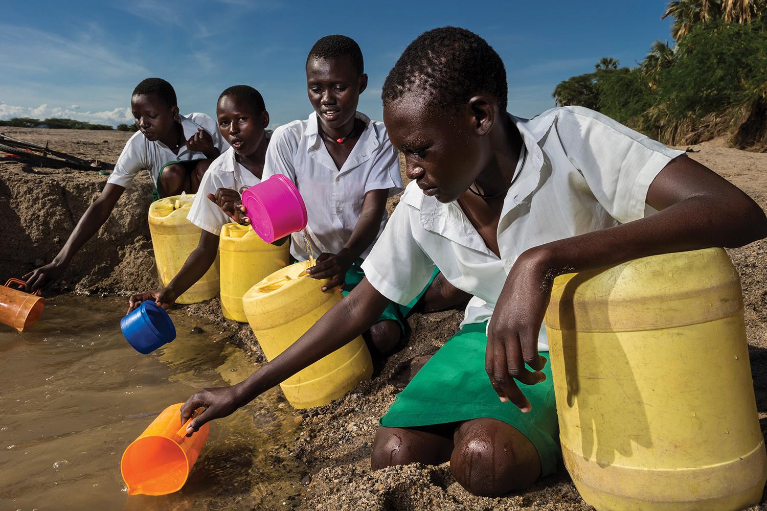 Girls from the Kalokol Girls Primary School fetch water from a dry riverbed to carry back to their school, which does not have access to running water. 