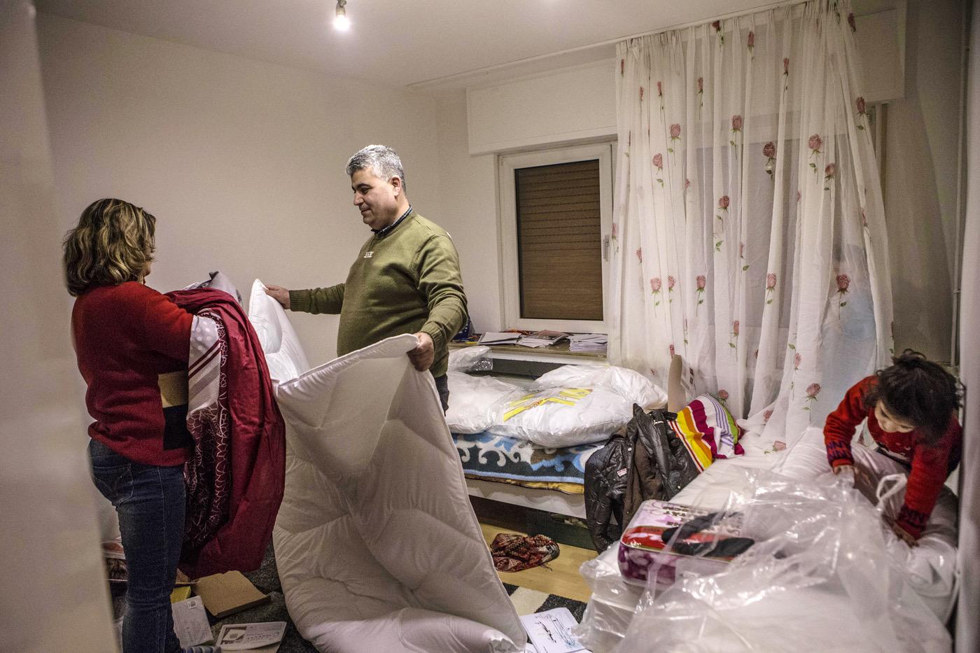 Mohammed and Falak prepare the beds for their children in their new house in Bonn, Germany. © 2017 Anna Pantelia