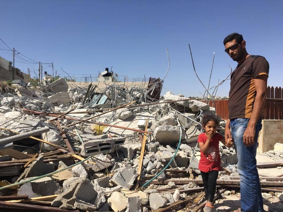 Ashraf Fawaqa and his daughter Sima, 4, stand next to the rubble of their East Jerusalem home on May 15; Israeli authorities demolished the house on May 4 because they lacked a permit.