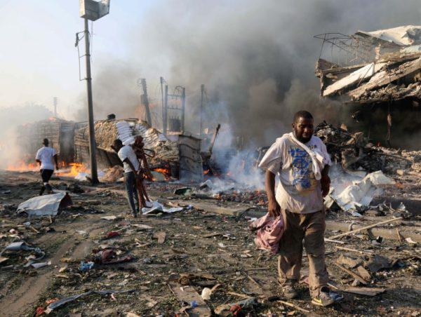 Civilians walk at the scene of an explosion in KM4 street in the Hodan district of Mogadishu, Somalia October 14, 2017