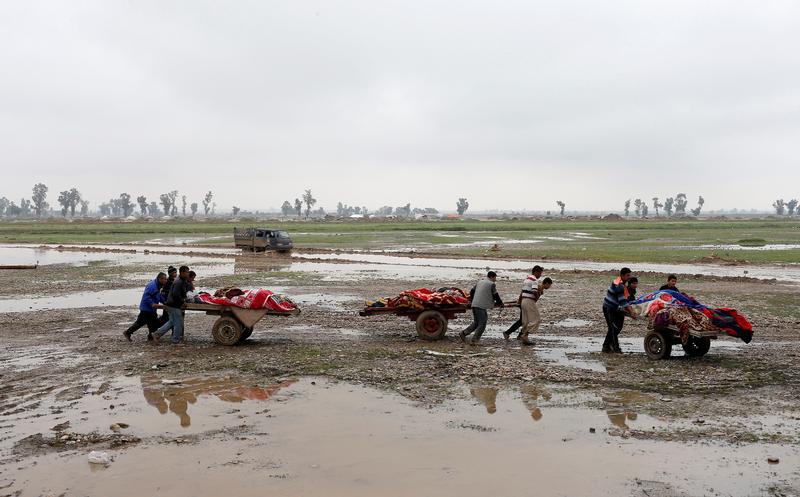 Relatives carry the bodies of civilians killed in an attack in New Mosul neighborhood of west Mosul on March 17, 2017. © 2017 Reuters
