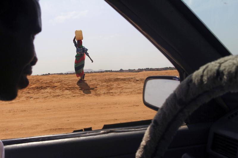 A woman carries water in Al Fashir, capital of North Darfur, Sudan, September 6, 2016.