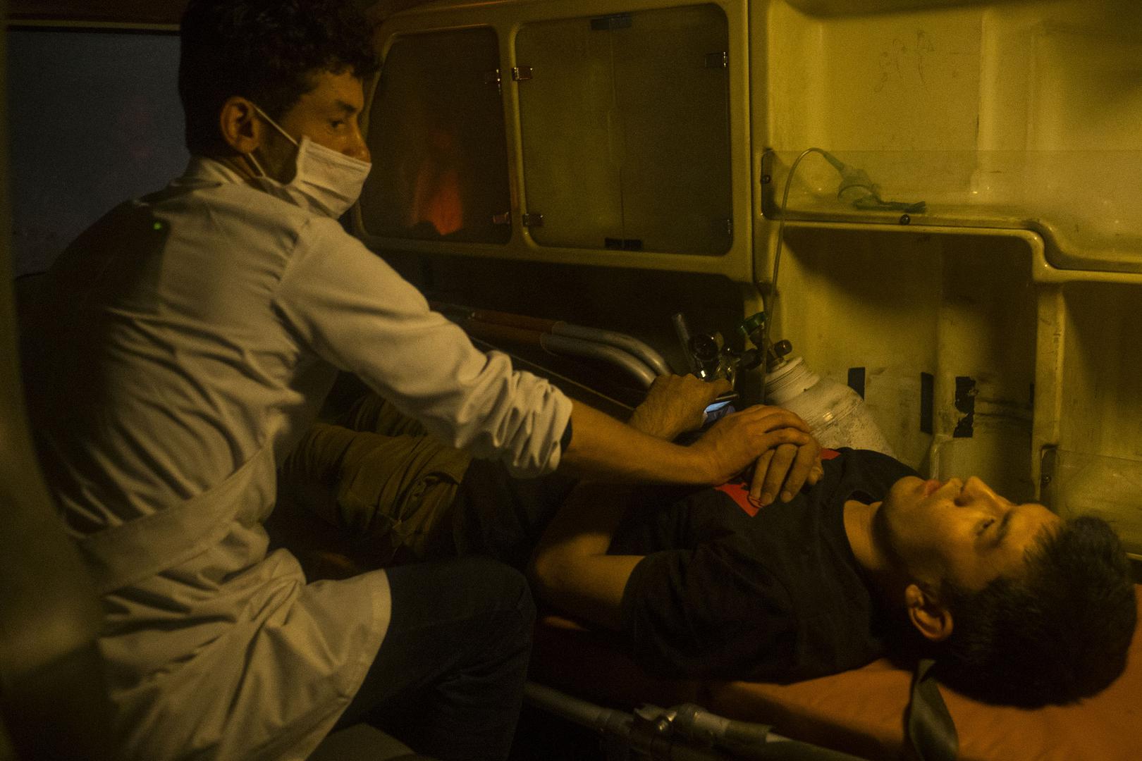 A medic assists an injured man following the attack on the American University of Afghanistan in Kabul, August 24, 2016.