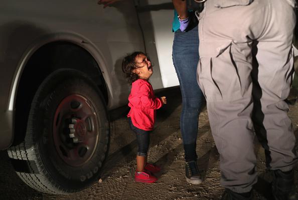 A two-year-old Honduran asylum seeker cries as her mother is searched and detained near the US-Mexico border on June 12, 2018, in McAllen, Texas. Customs and Border Protection (CBP) is executing the Trump administration's 'zero tolerance' policy towards u