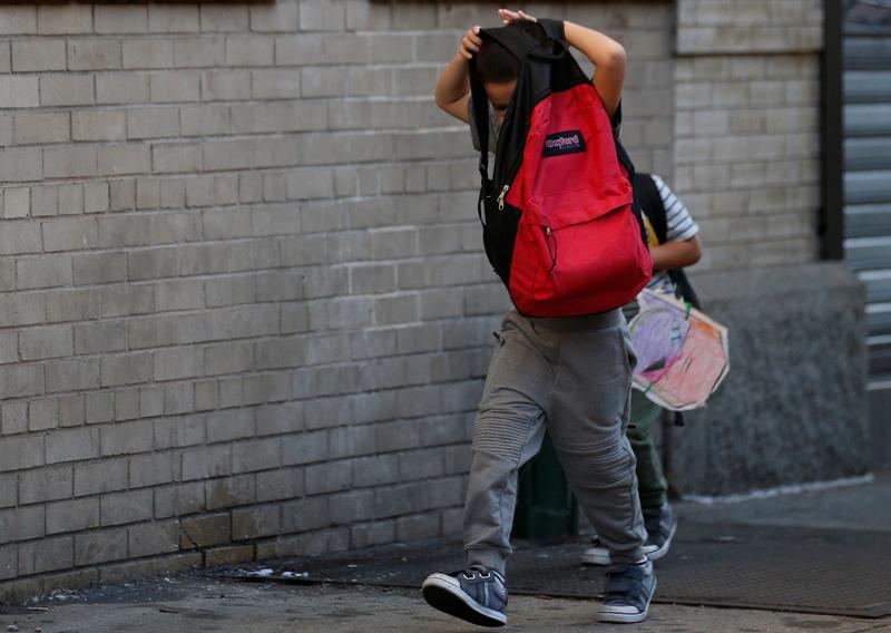 Children cover their faces as they are escorted to the Cayuga Center, which provides foster care and other services to immigrant children separated from their families, in New York City, U.S., July 10, 2018.