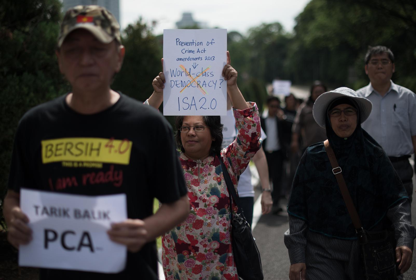 Activists hold placards during a protest against an amendment to a 1959 crime prevention act that would give police a stronger hand, outside the parliament house in Kuala Lumpur on September 30, 2013.