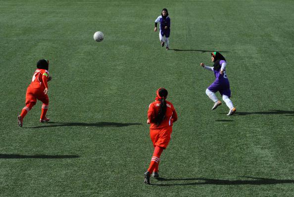 Afghan female football players from Isteghlal (in purple) and Afghan (red) compete during the women's football tournament final match in Kabul on December 6, 2013. 
