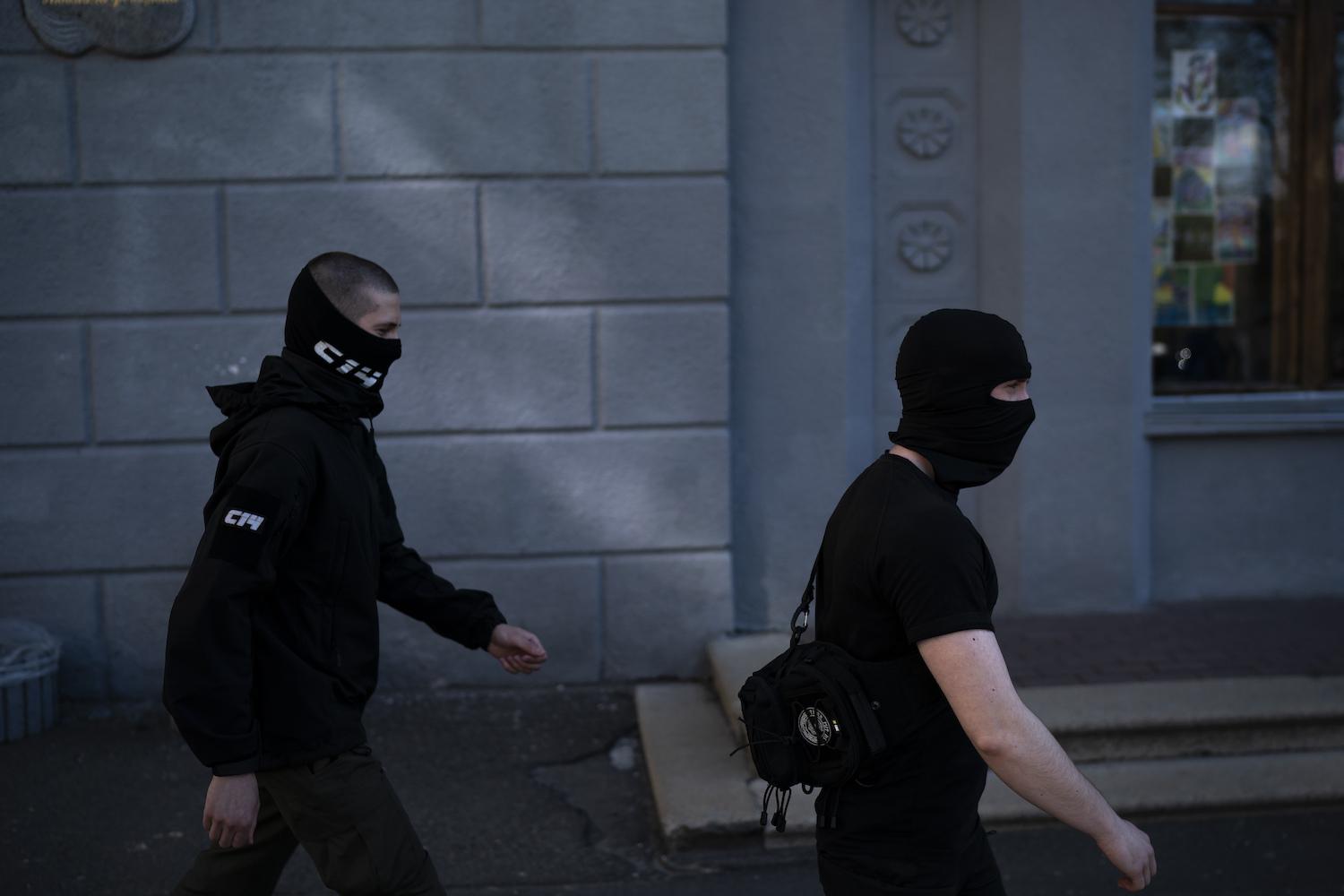 Members of the C14 far right group, some of them wearing balaclavas, march toward an Russian orthodox church in Kiev, Ukraine